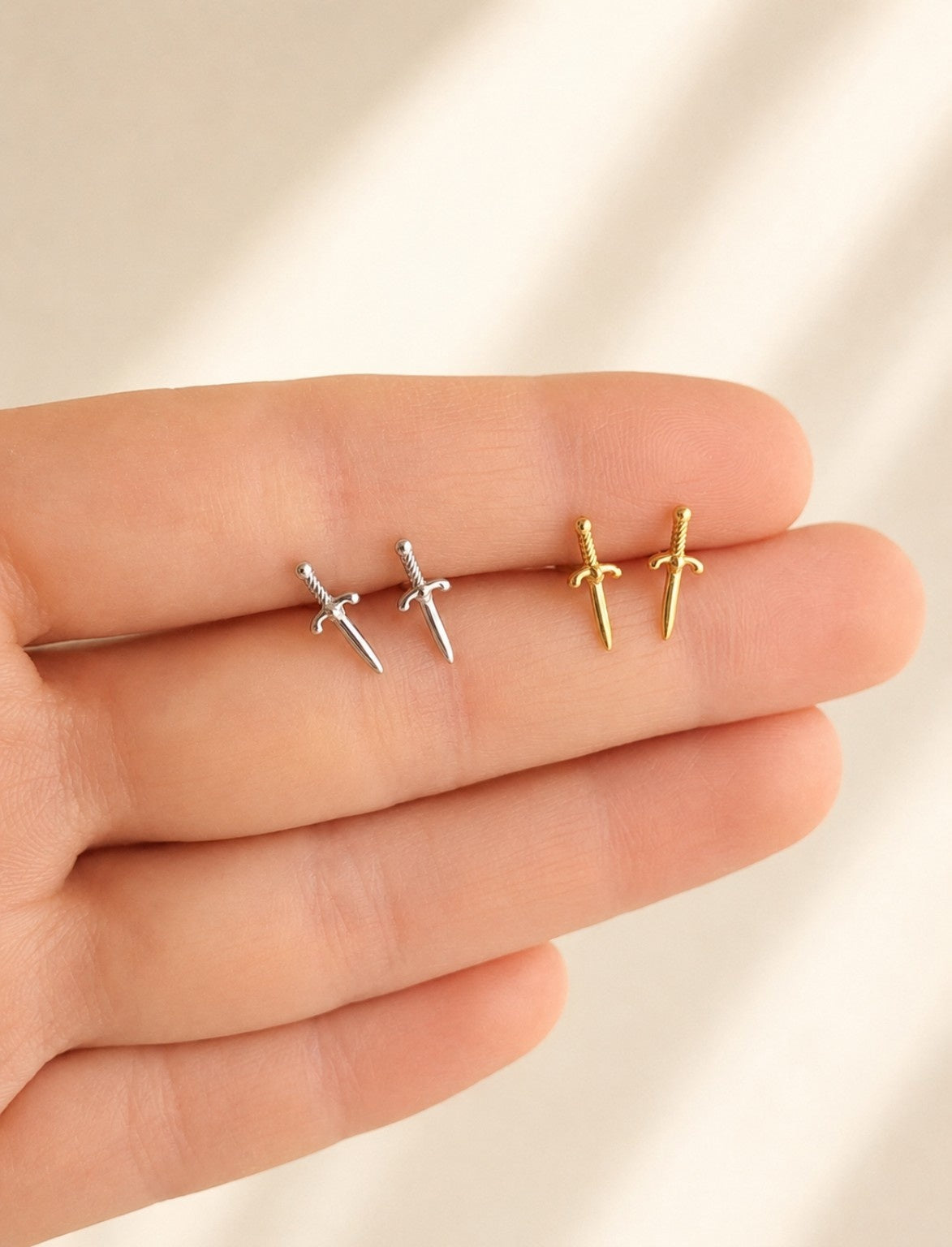 Dainty sword stud earrings crafted from sterling silver with 18K gold plating.