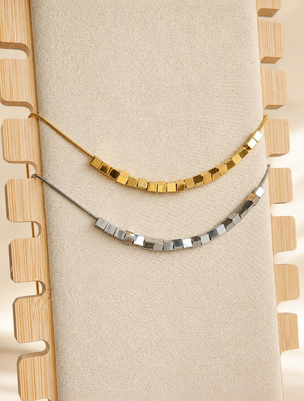 Cube bead spinner necklace with 18K gold plating and a non-tarnish finish.