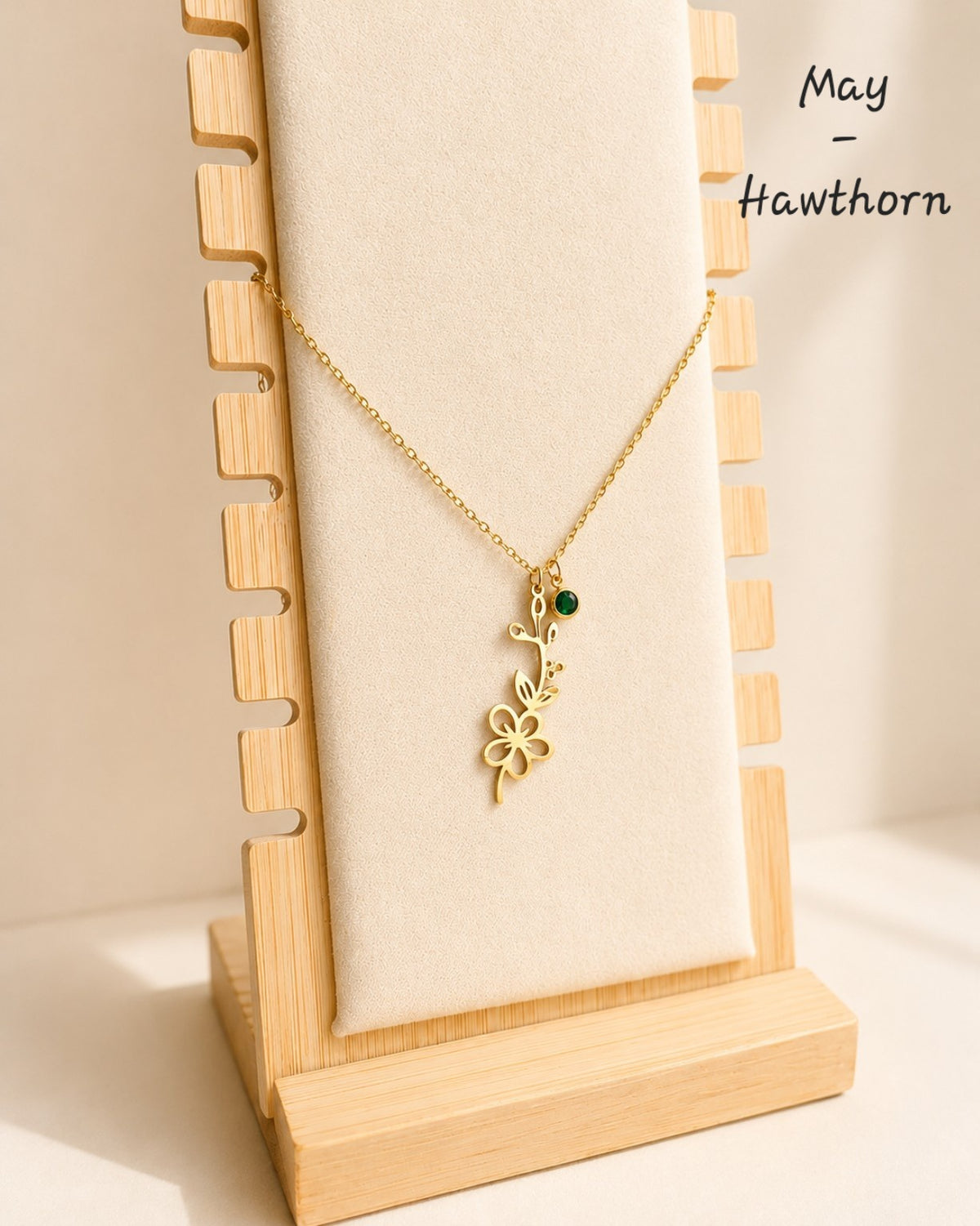 Gold birth flower necklace featuring a birthstone and engraved floral pendant.