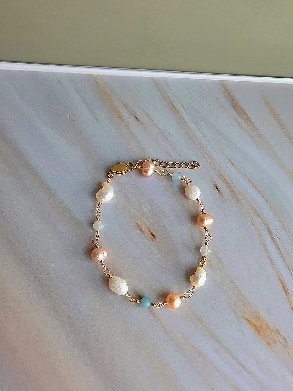 Natural freshwater pearl bracelet accented with aquamarine beads and gold details.