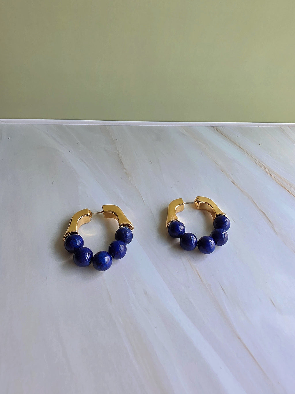 Natural lapis lazuli hoop earrings with polished gold-plated hoops.