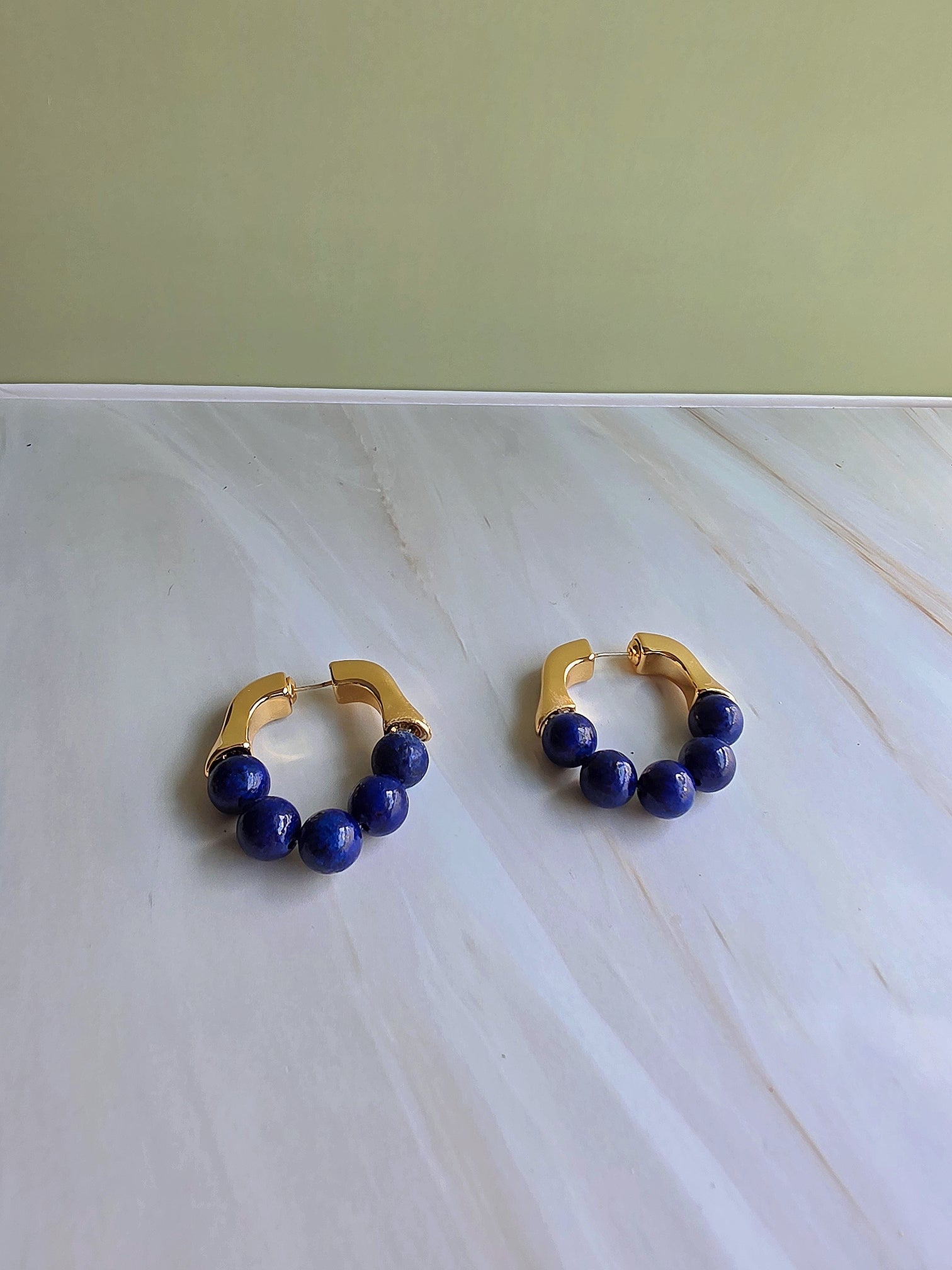Natural lapis lazuli hoop earrings with polished gold-plated hoops.