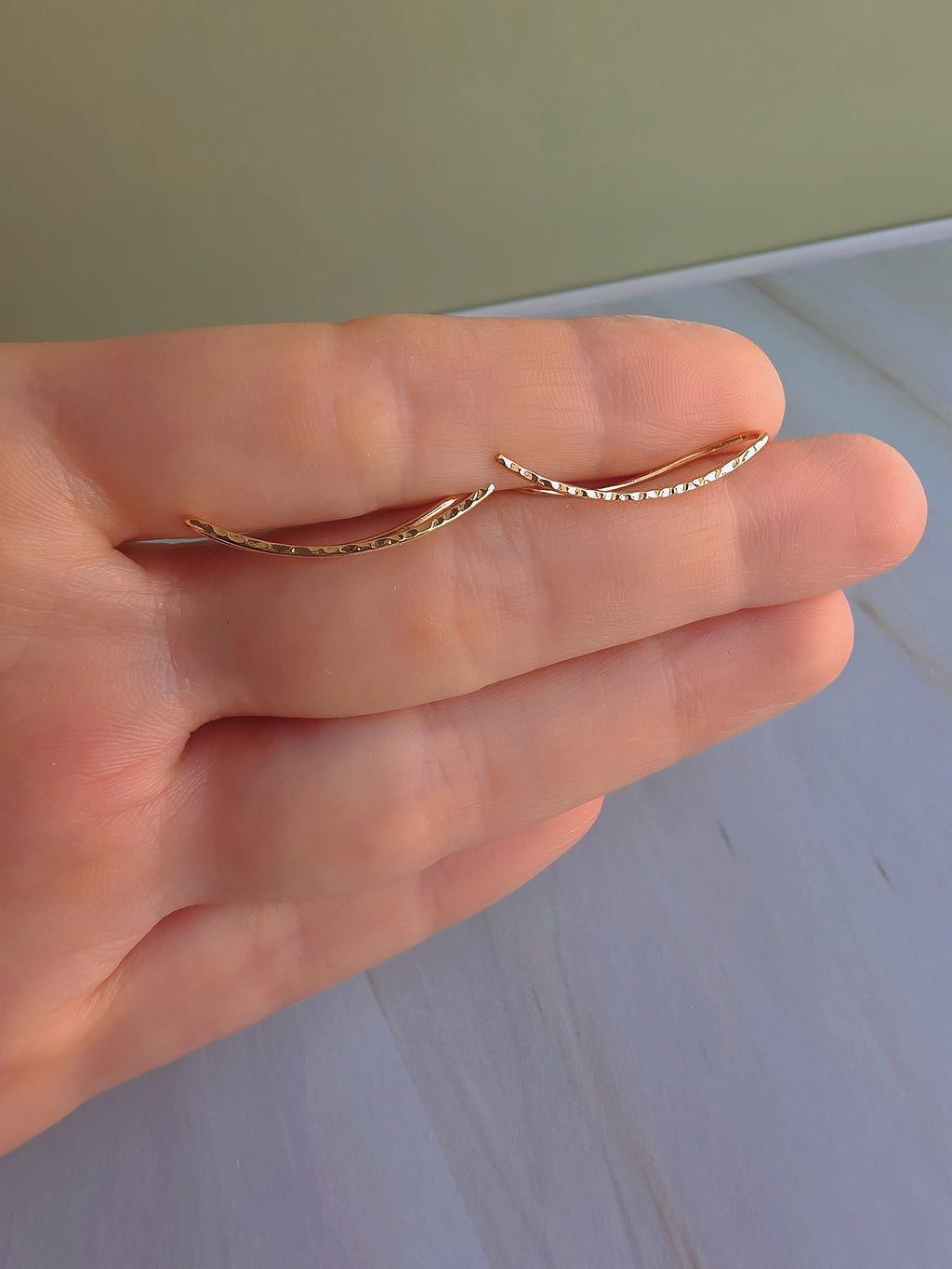 Gold-plated ear climber earrings with a sleek curved silhouette.