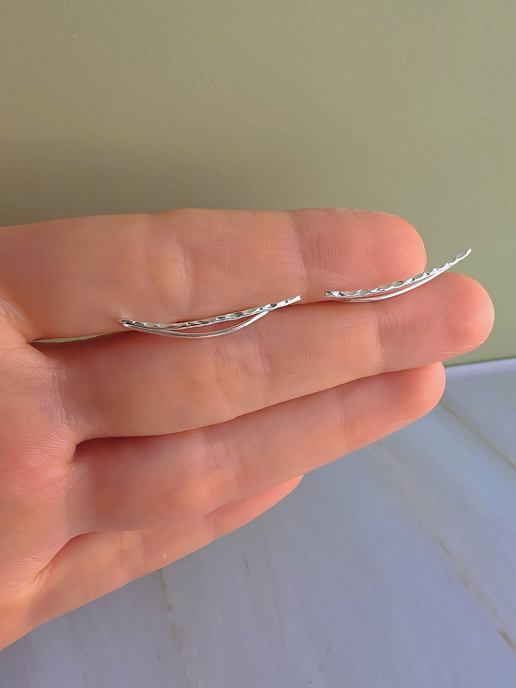 Modern ear crawler earrings with a textured hammered finish.