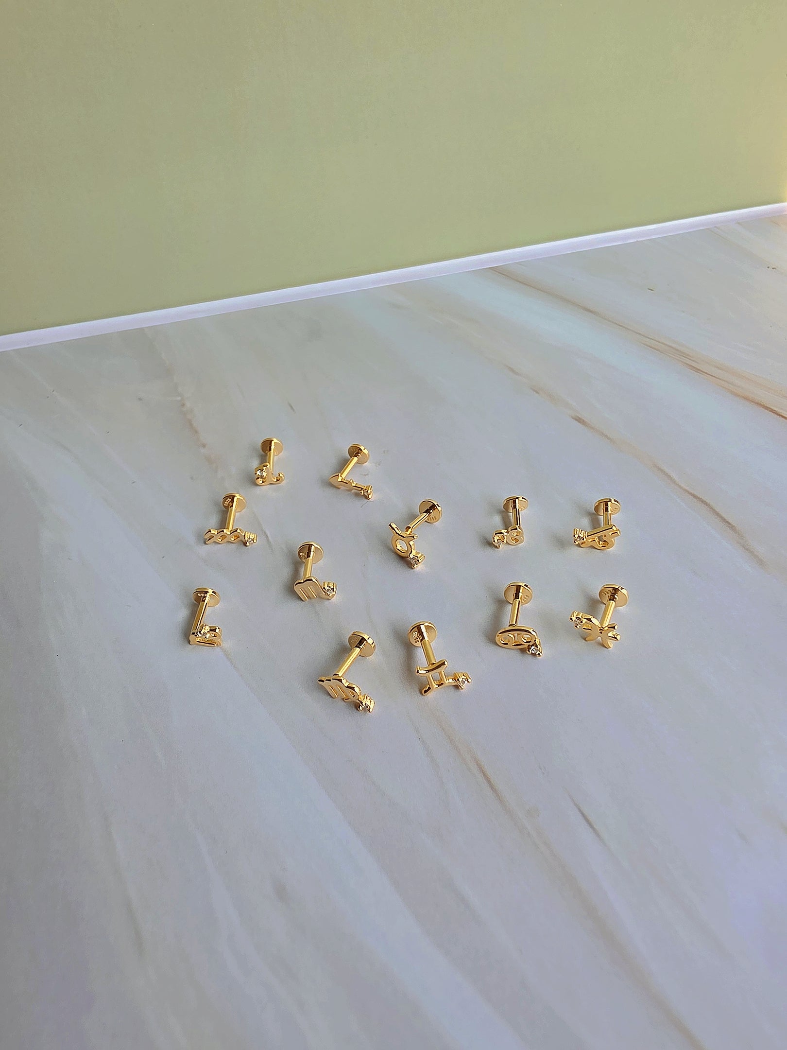Gold-plated zodiac constellation flat back earring for cartilage piercings.