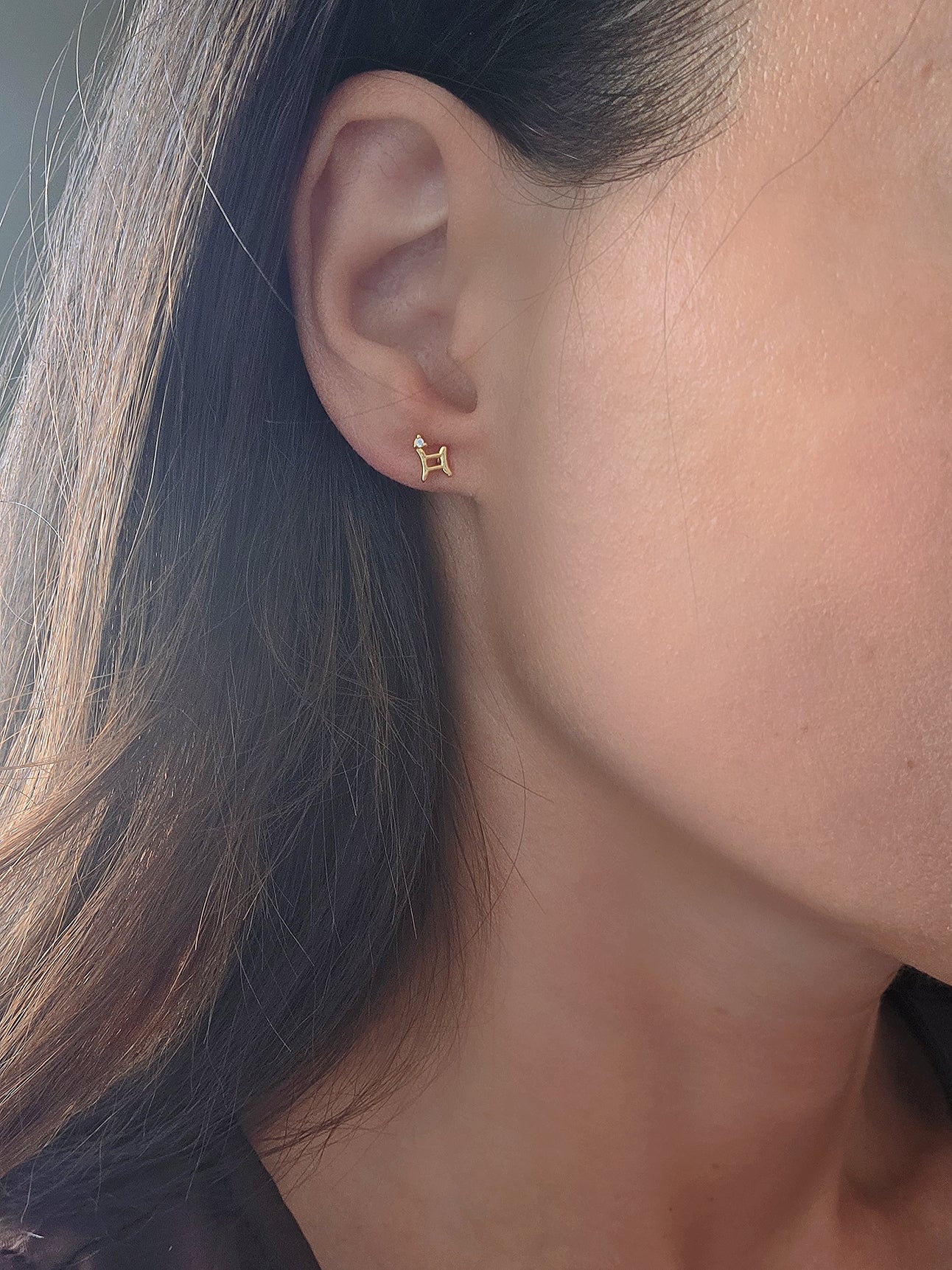 Minimalist zodiac sign cartilage earring in 18K gold plating.