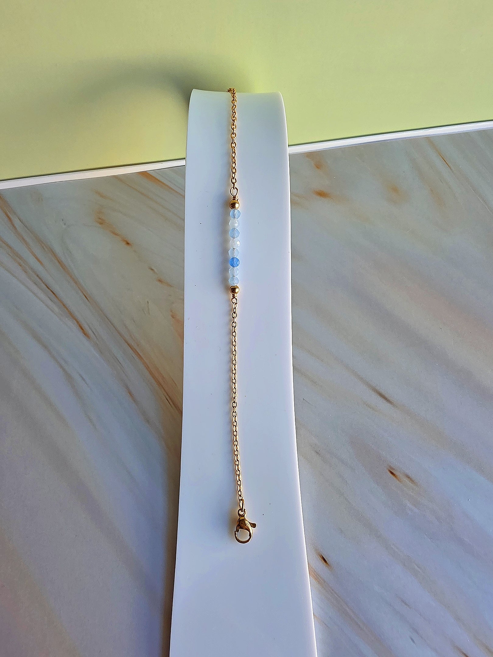 18K gold-plated gemstone bracelet available in Aquamarine, Emerald, or Moonstone.