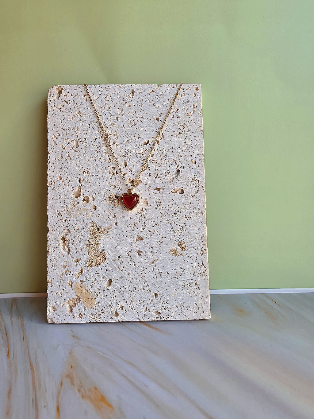 Minimalist heart necklace with a natural carnelian gemstone and gold-plated chain.