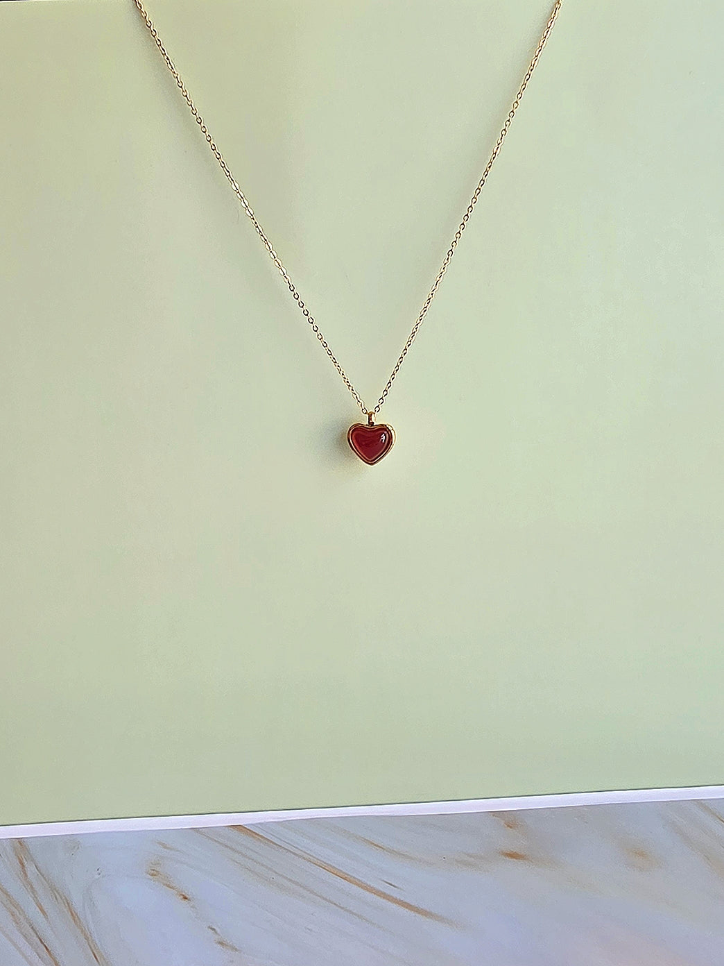 Gold-plated heart pendant necklace with genuine red carnelian crystal, perfect for layering.