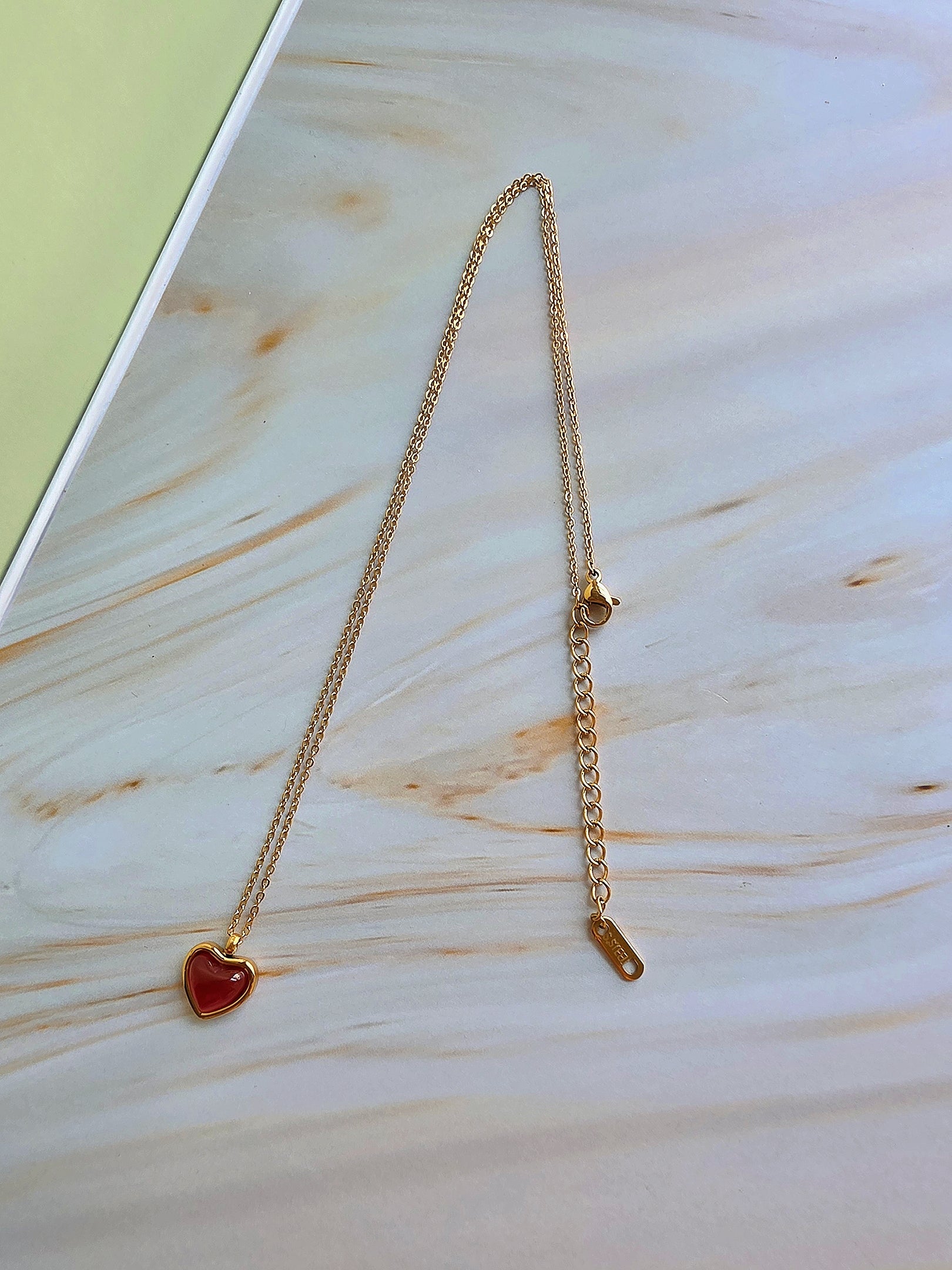 July birthstone necklace with a polished heart-shaped natural carnelian gemstone.