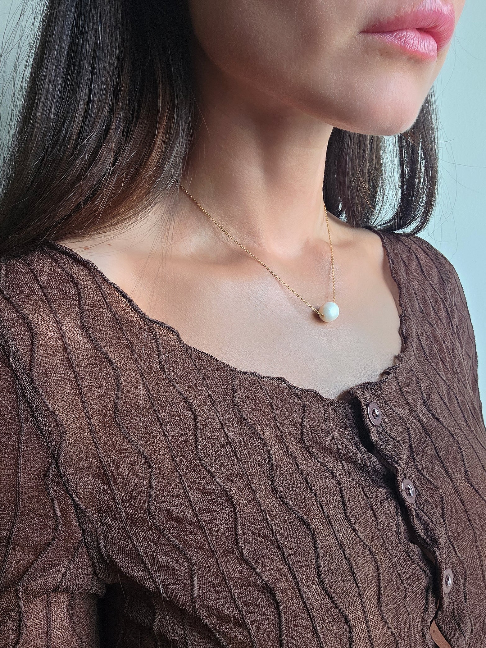 Minimalist freshwater pearl necklace featuring a polished 18K gold-plated finish.