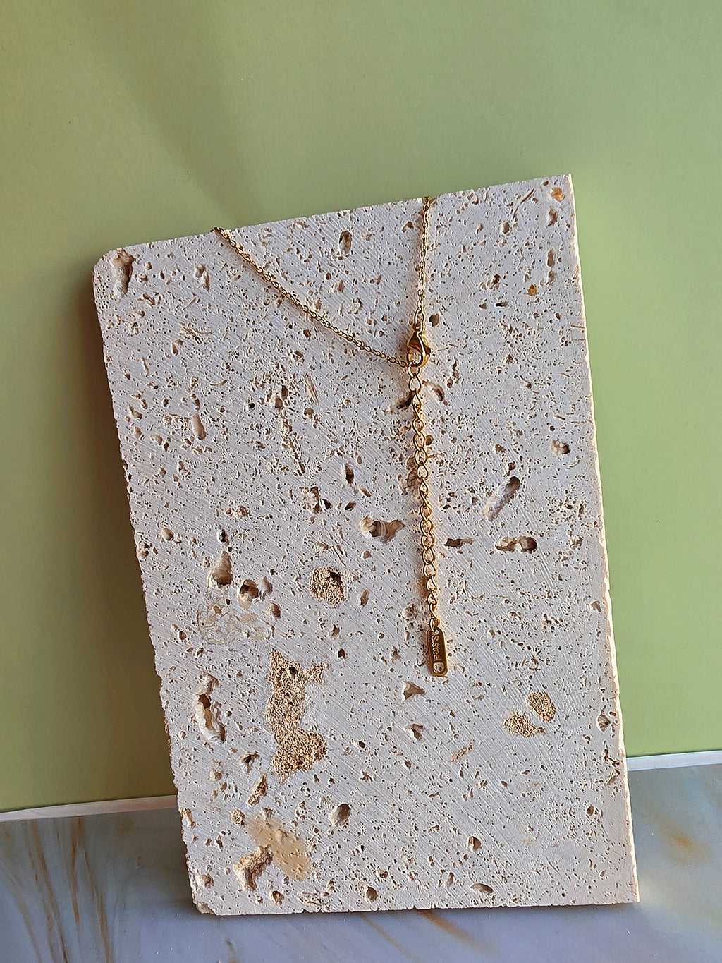 Square piece of porous material on a light green background