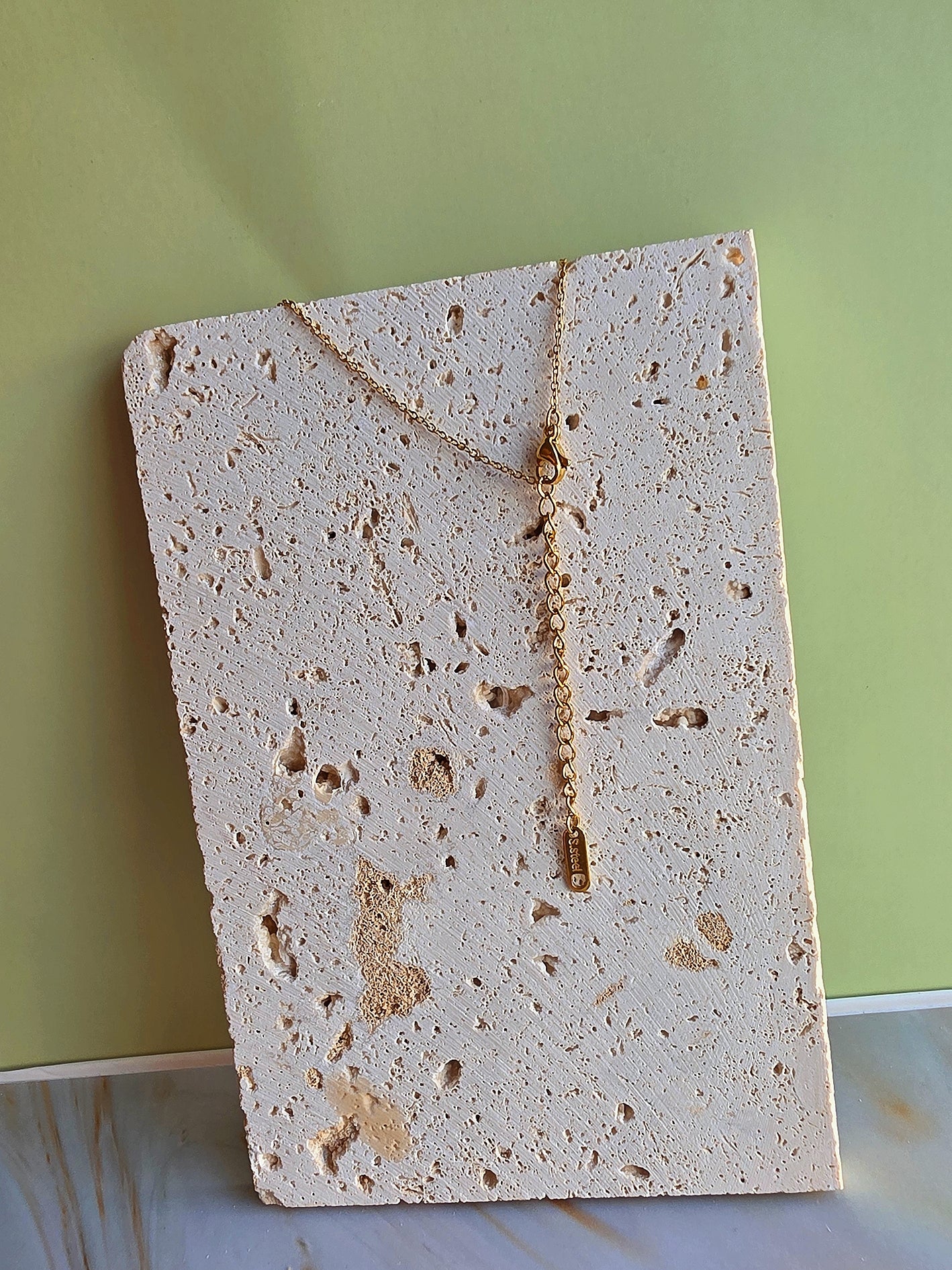 Square piece of porous material on a light green background