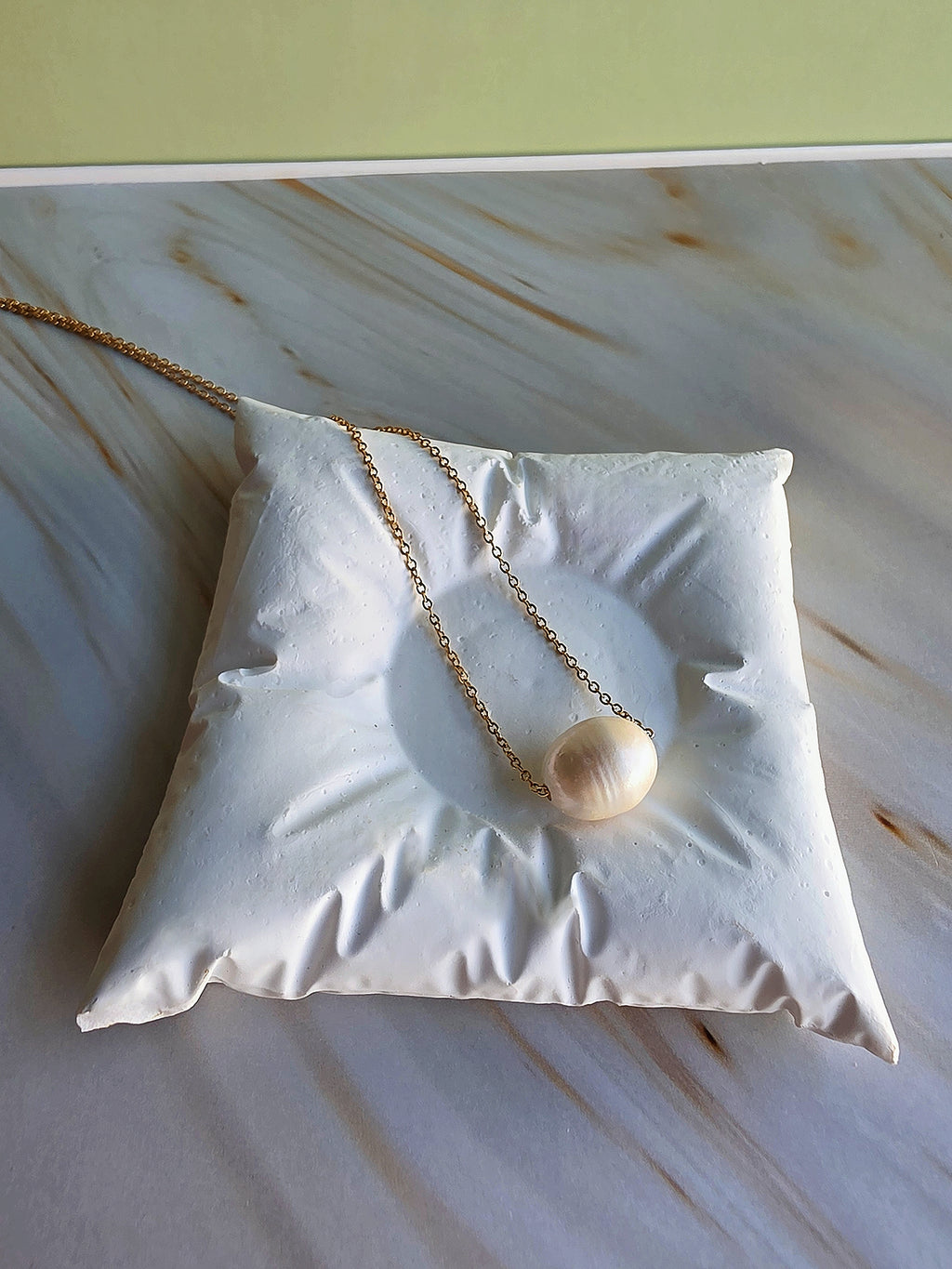 Genuine freshwater pearl necklace displayed on a gold-plated chain.