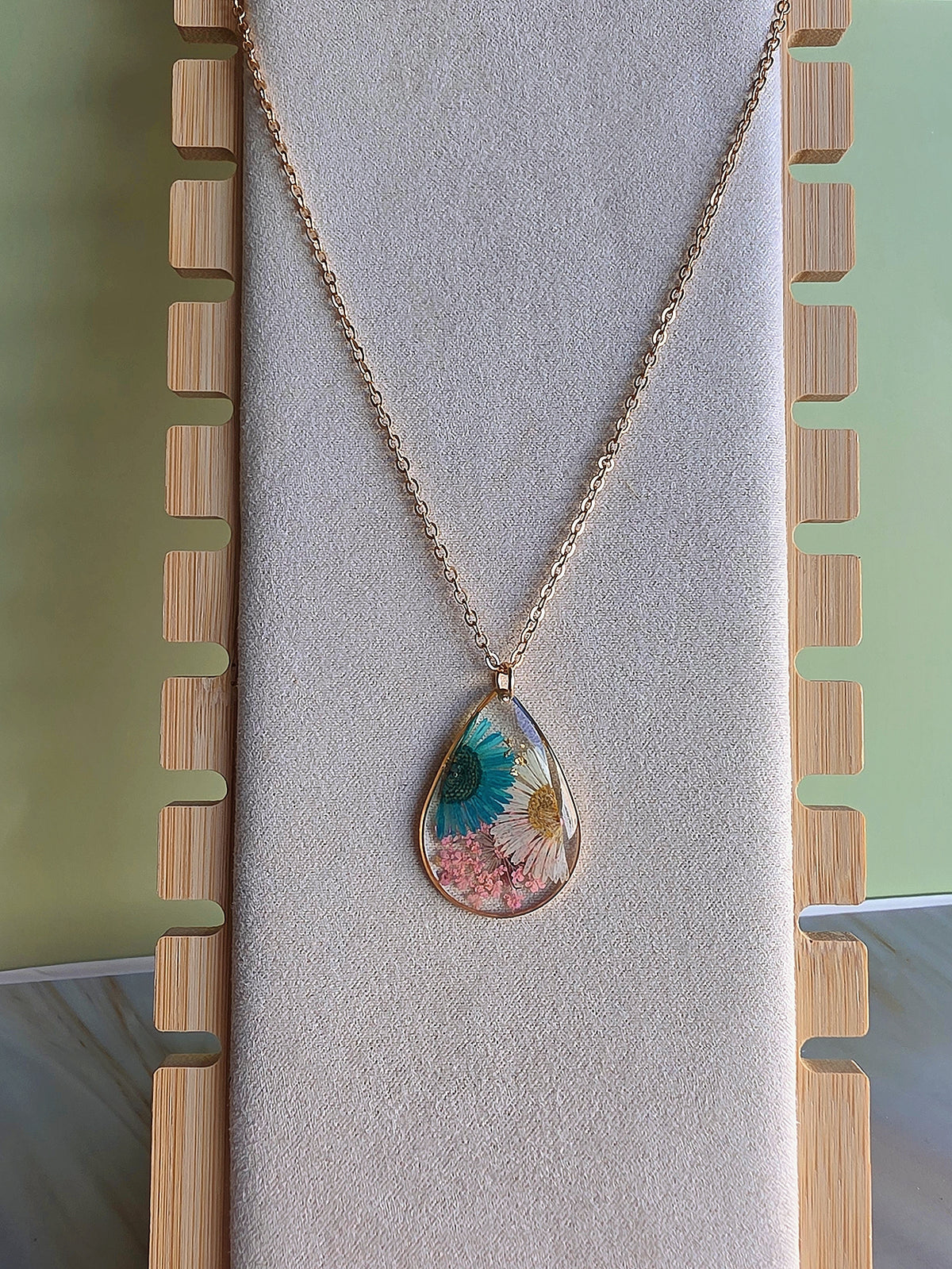Oval pressed flower necklace with colorful wildflowers.
