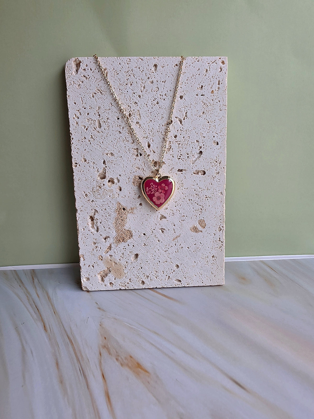 Nature-inspired heart necklace with genuine floral details.
