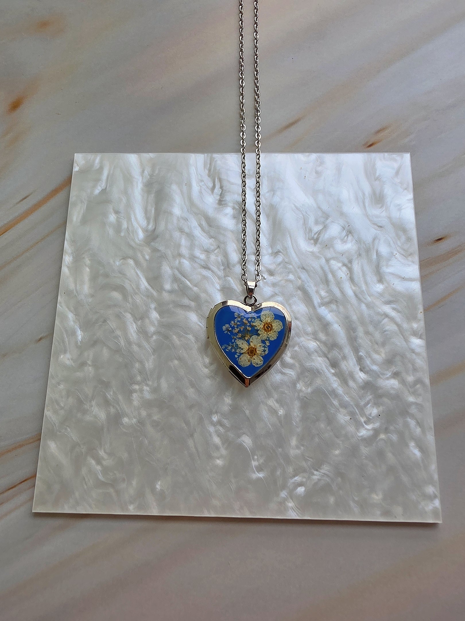Colorful heart locket necklace made with genuine preserved flowers.