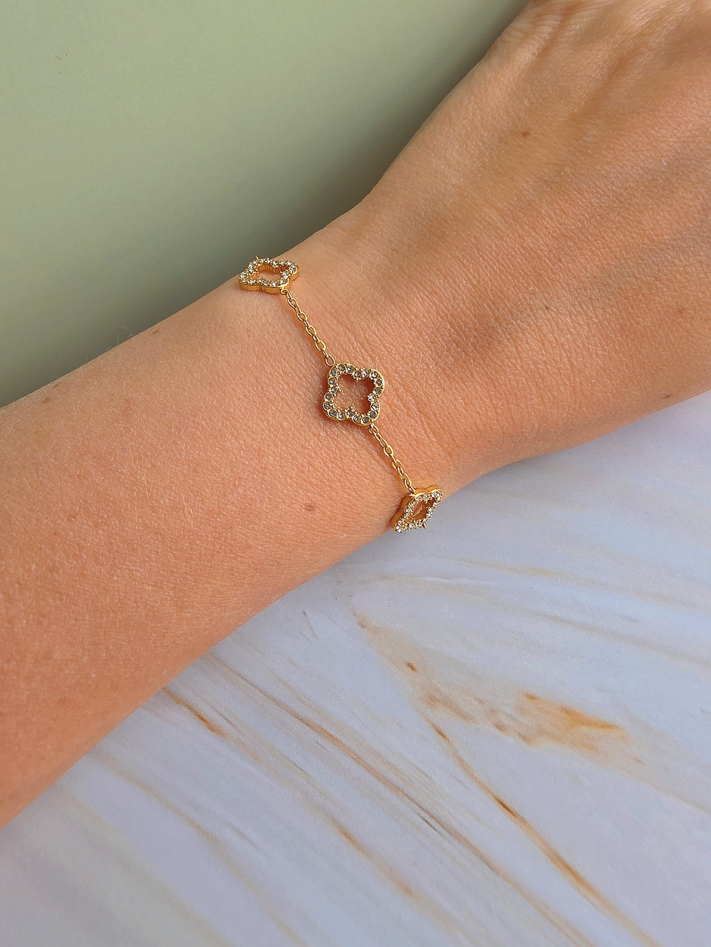 Adjustable four leaf clover bracelet with a polished 18K gold-plated chain.