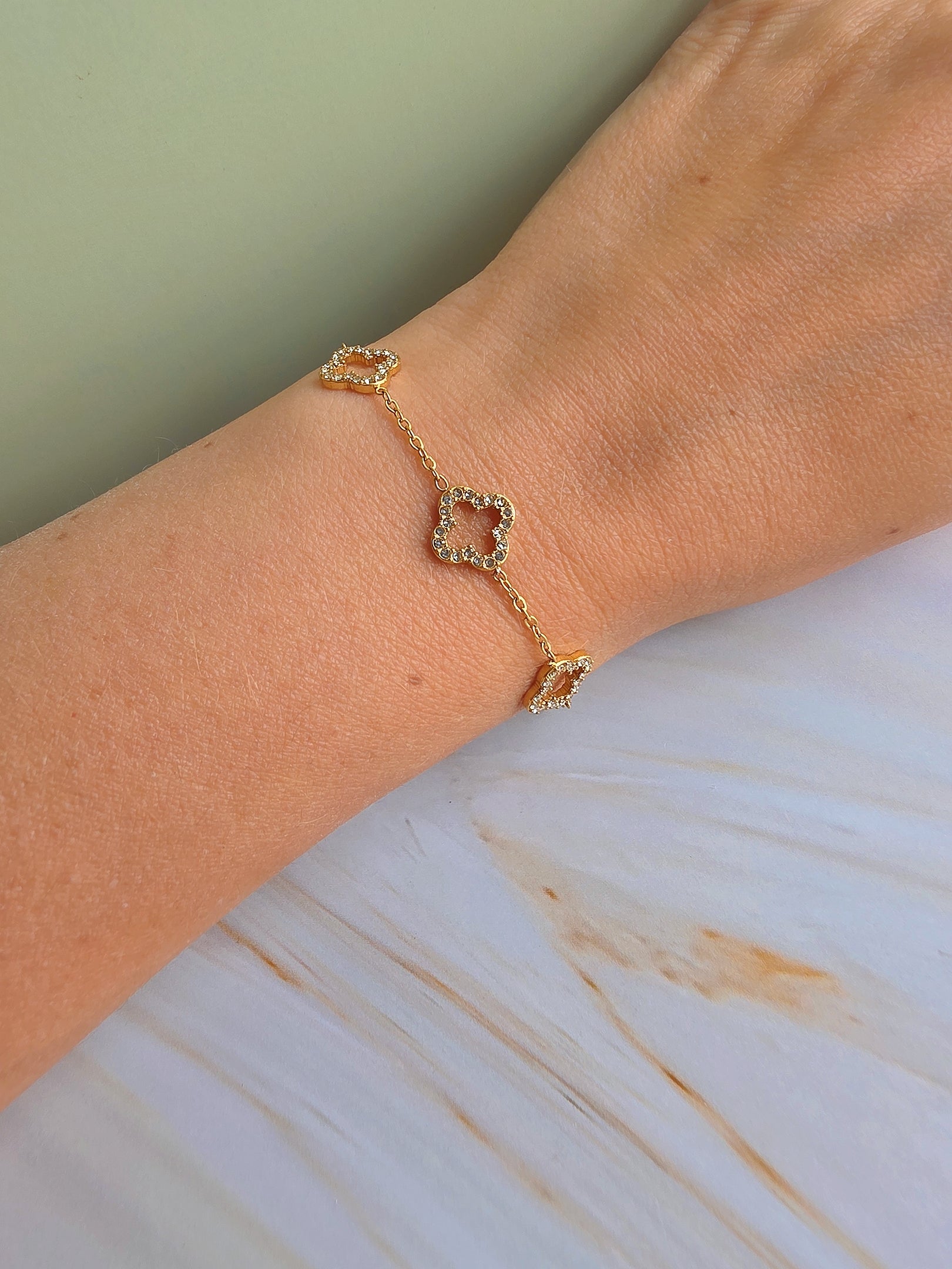 Adjustable four leaf clover bracelet with a polished 18K gold-plated chain.