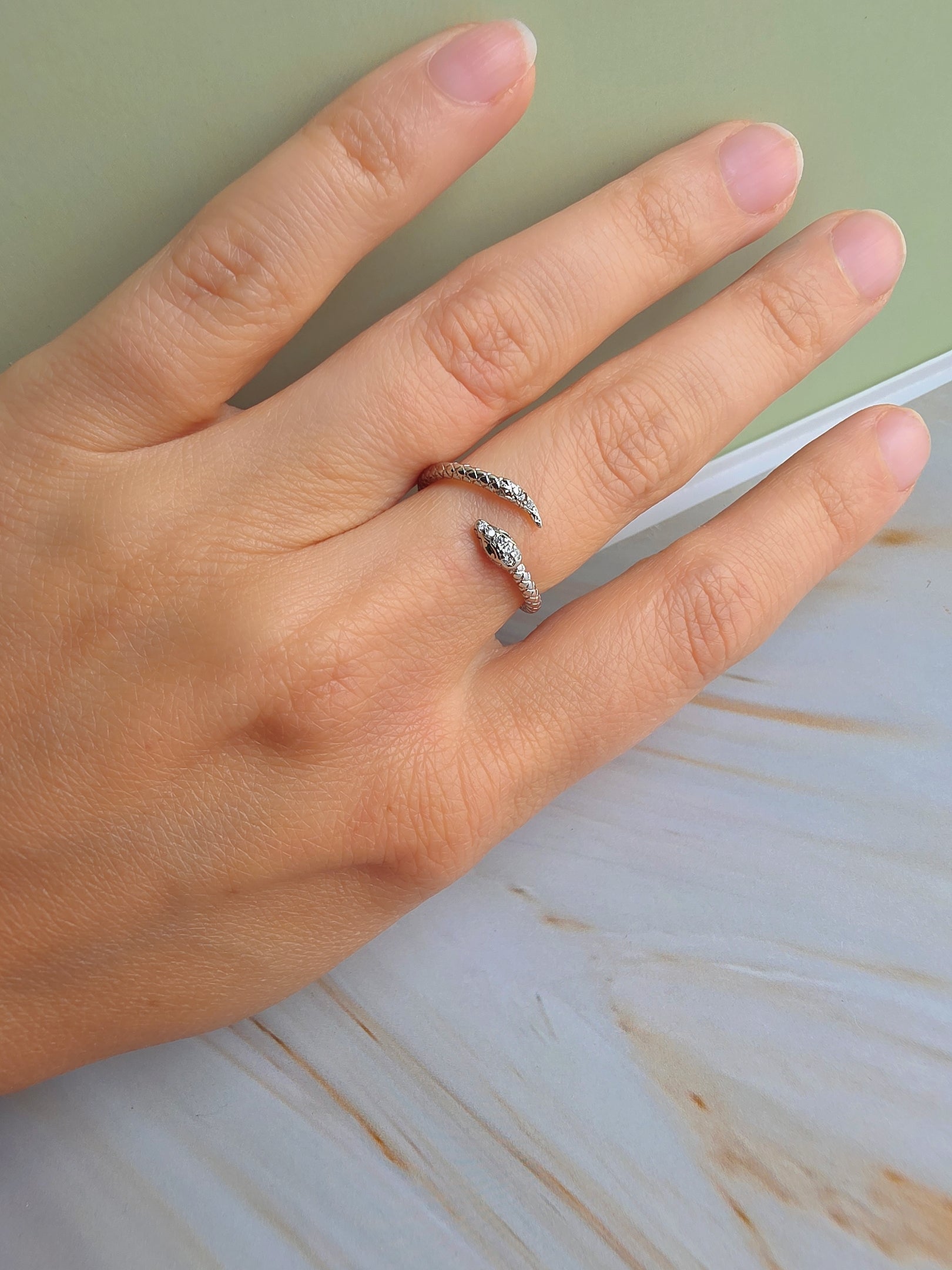 Gold and silver snake rings with sparkling cubic zirconia and open adjustable bands.
