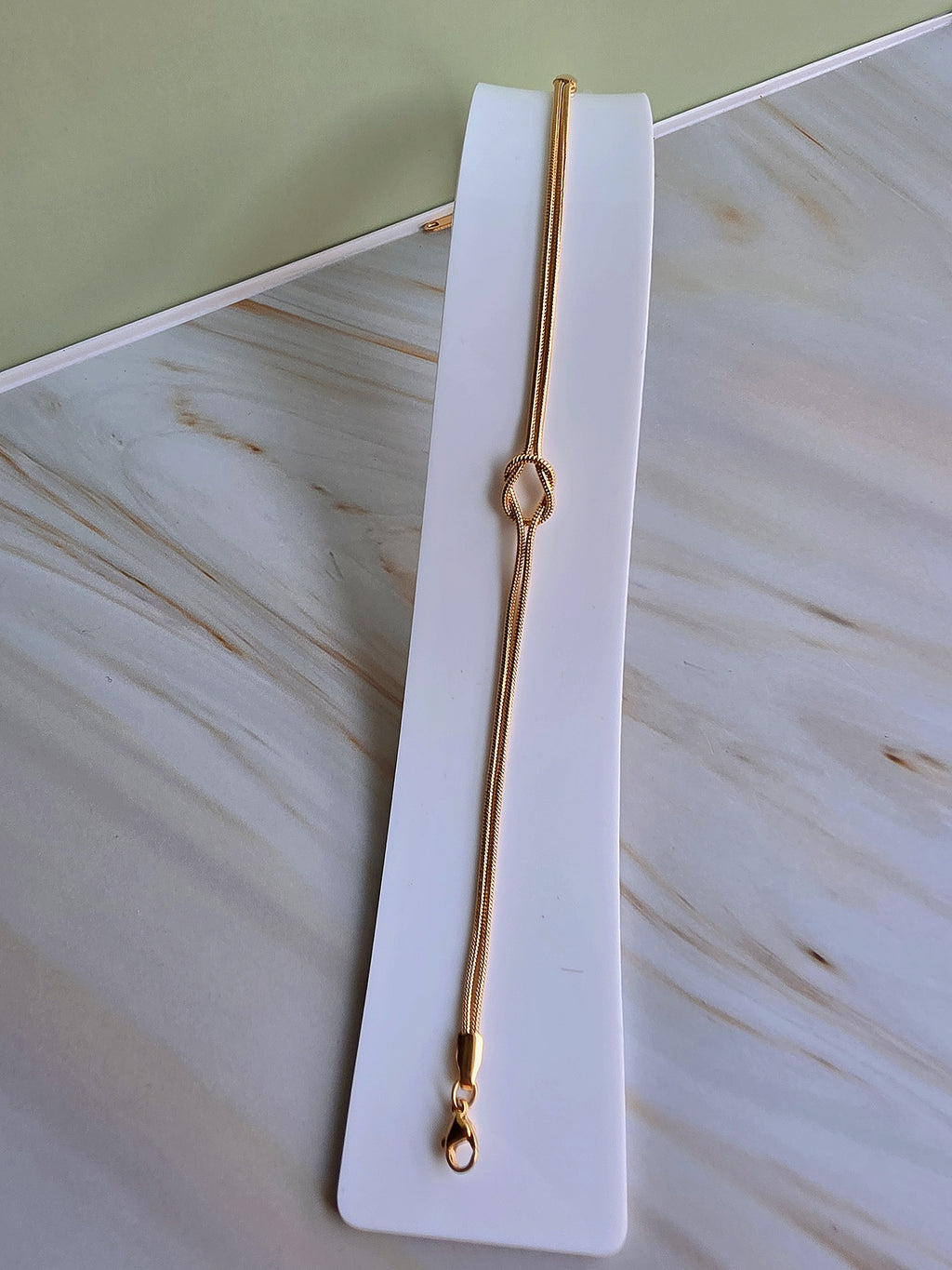 Minimalist matching couple bracelets with elegant knot charms in adjustable gold and silver finishes.