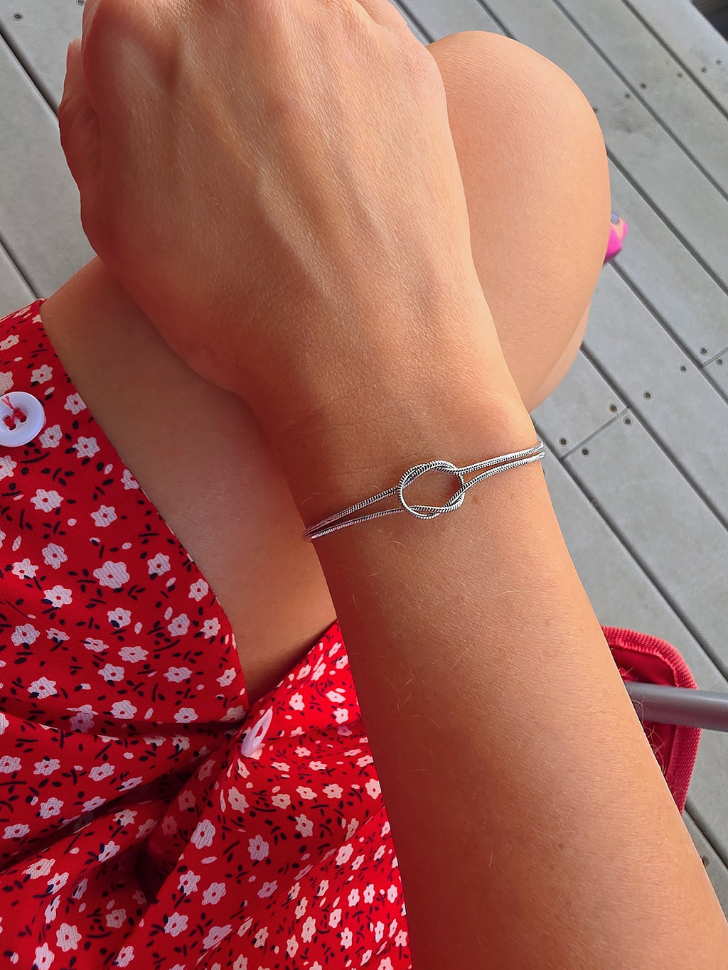 Gold and silver matching couple bracelets featuring an elegant love knot centerpiece.