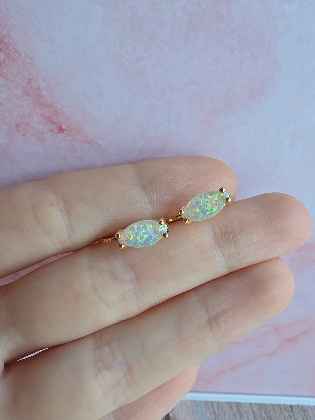 Elegant marquise-cut white opal huggie earrings in gold and silver finishes.