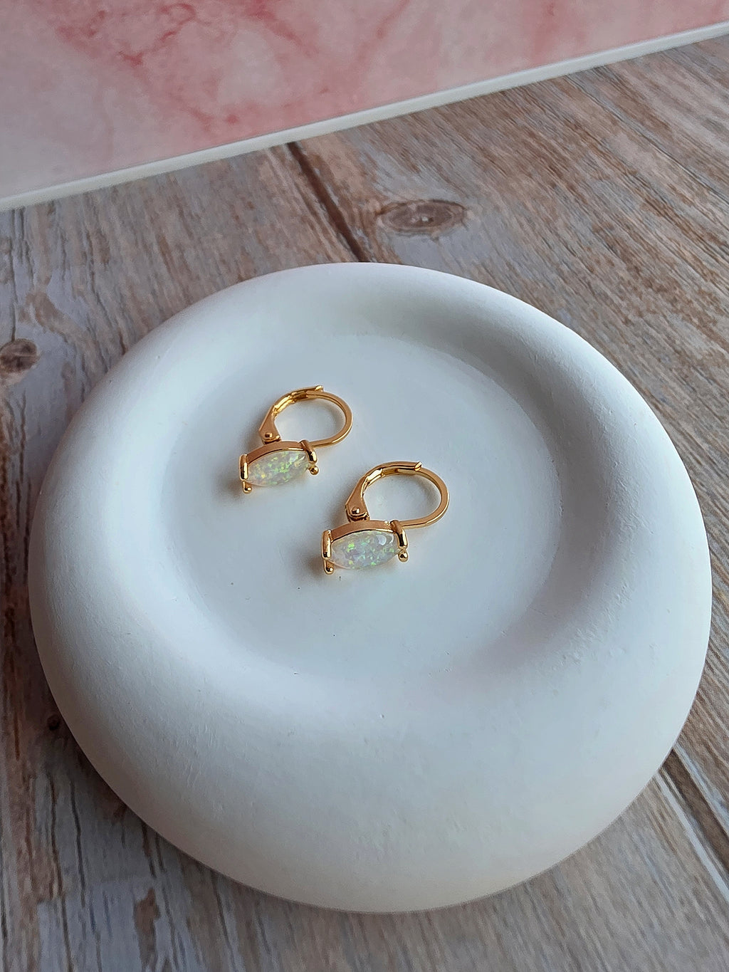 Women's marquise opal hoop earrings with sparkling white fire opals.