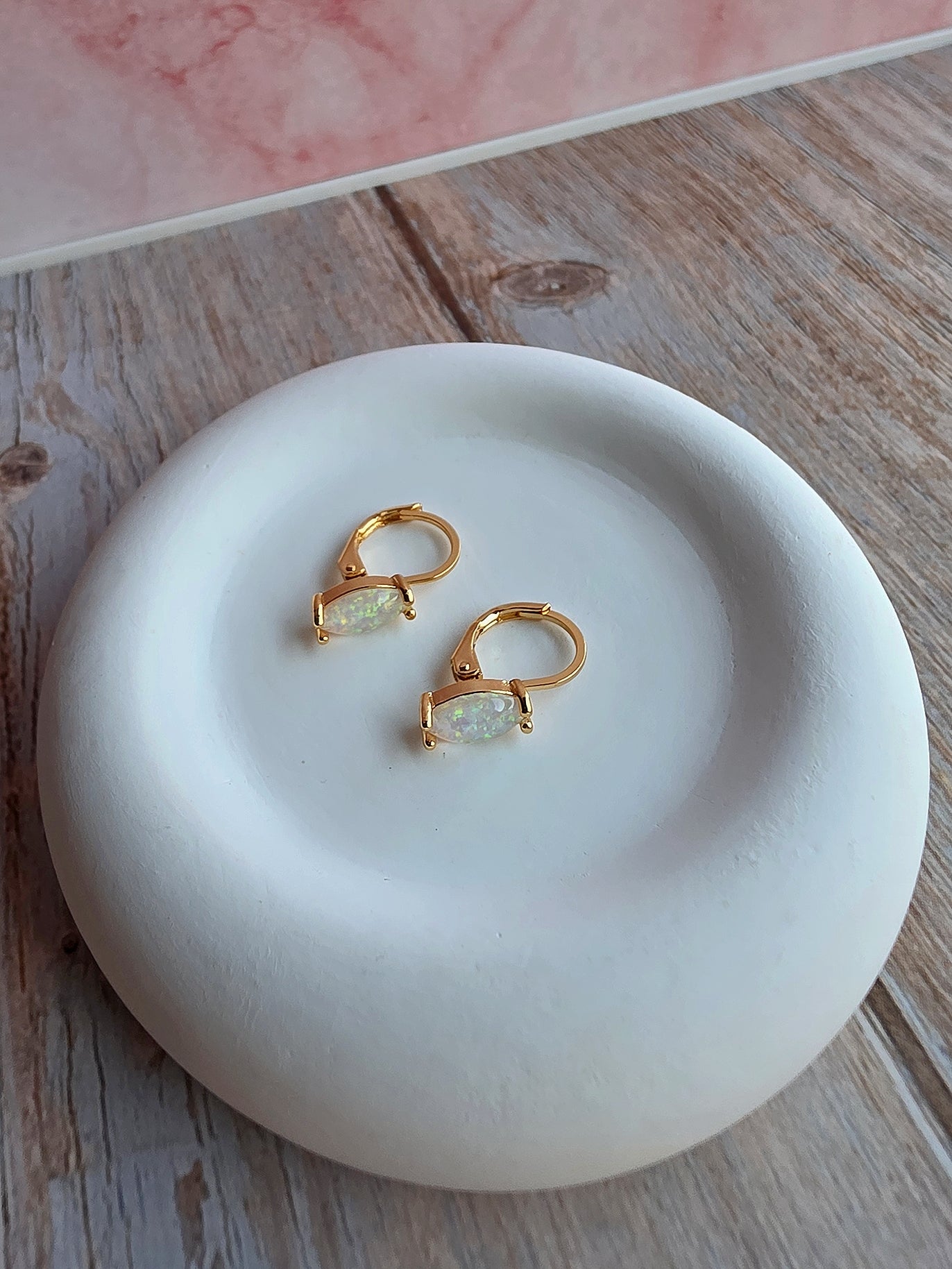 Women's marquise opal hoop earrings with sparkling white fire opals.