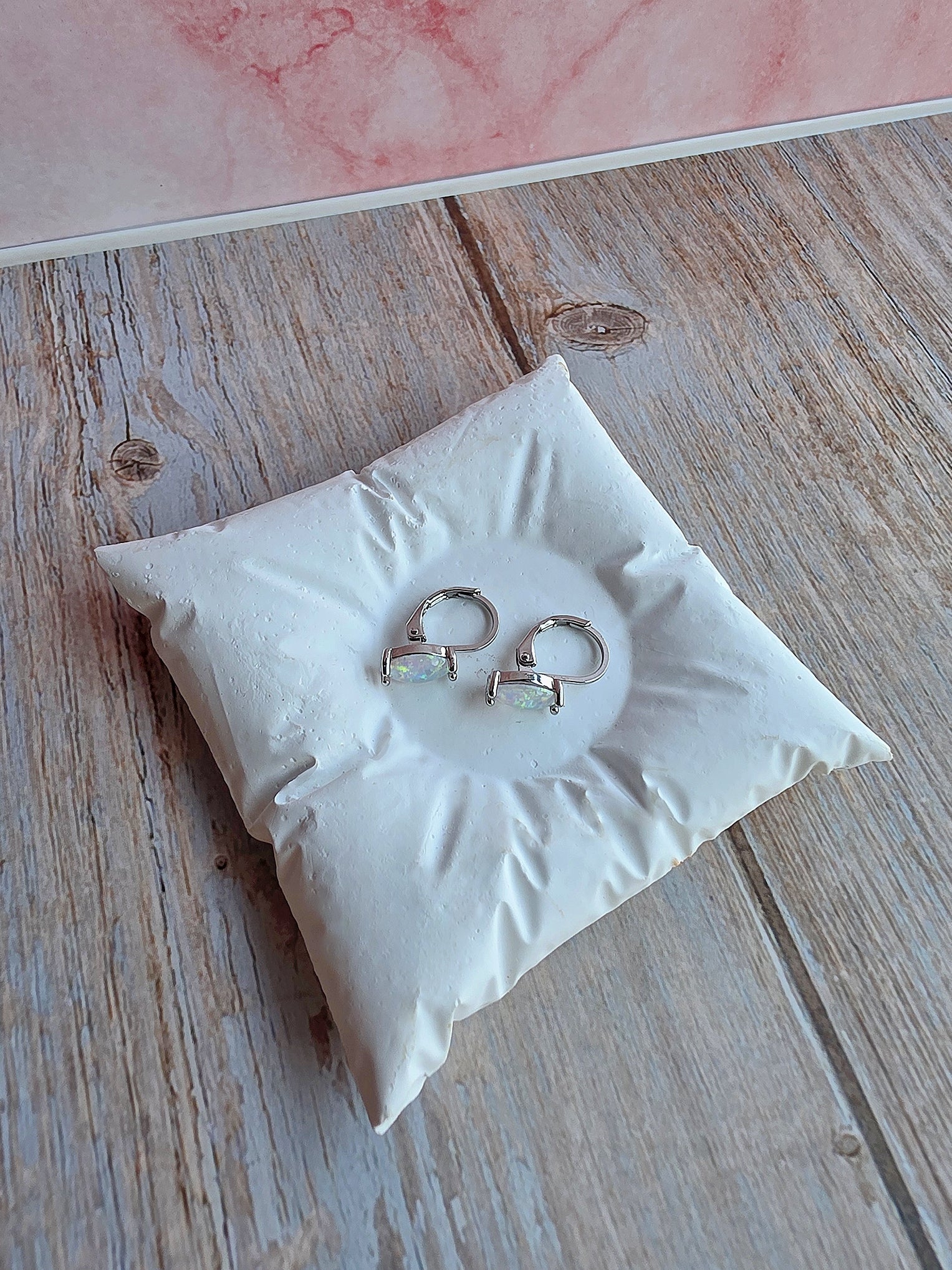 Delicate marquise opal huggie hoops with polished gold-plated settings.