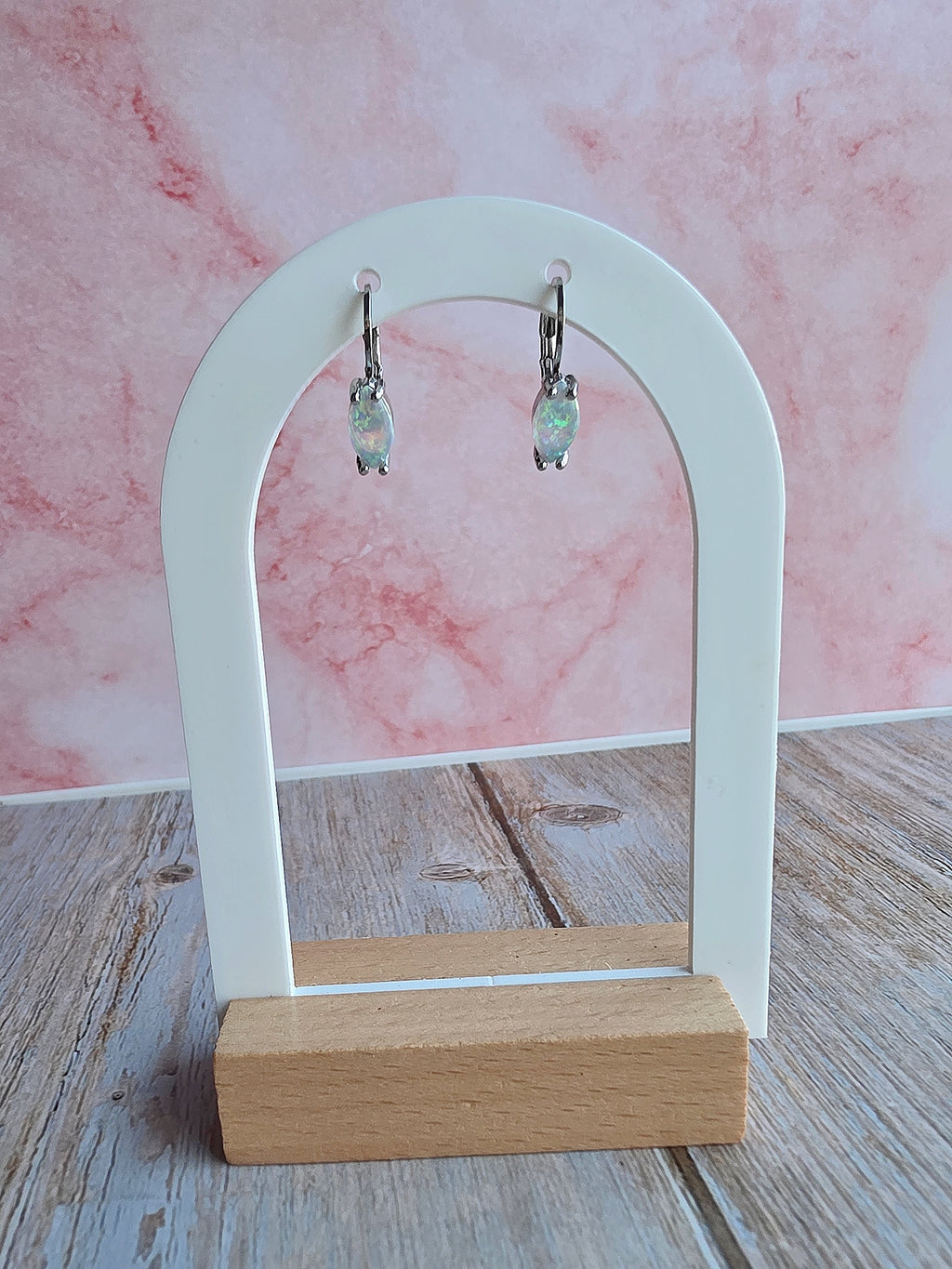 White fire opal huggie earrings in gold and silver, ideal for gifting.