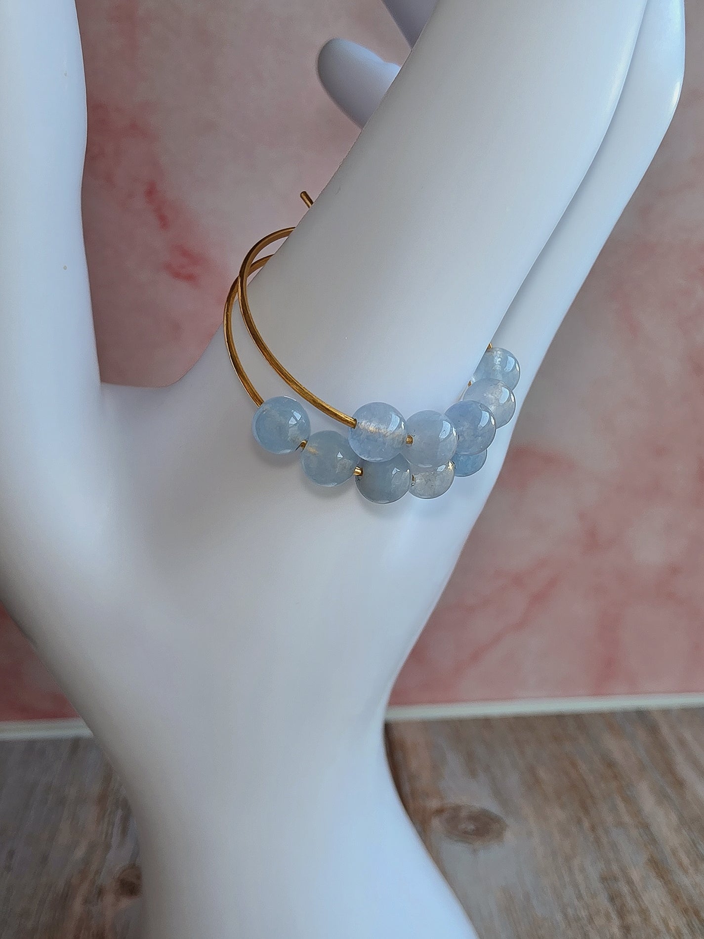 Minimalist aquamarine hoop earrings with polished 18K gold-plated hoops.