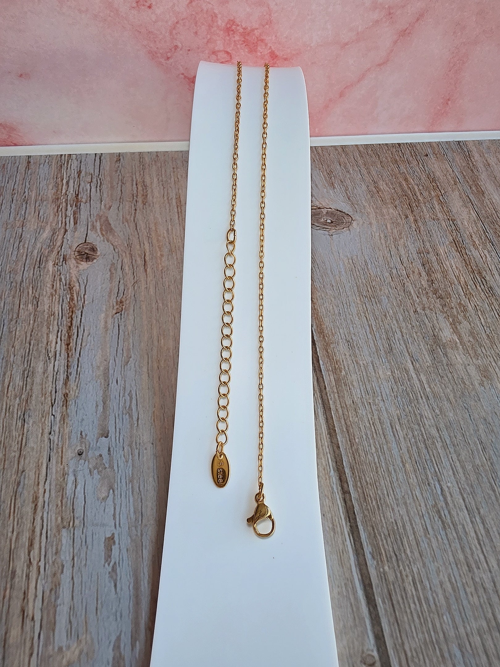Women's 18K gold-plated safety pin necklace with shimmering CZ details.