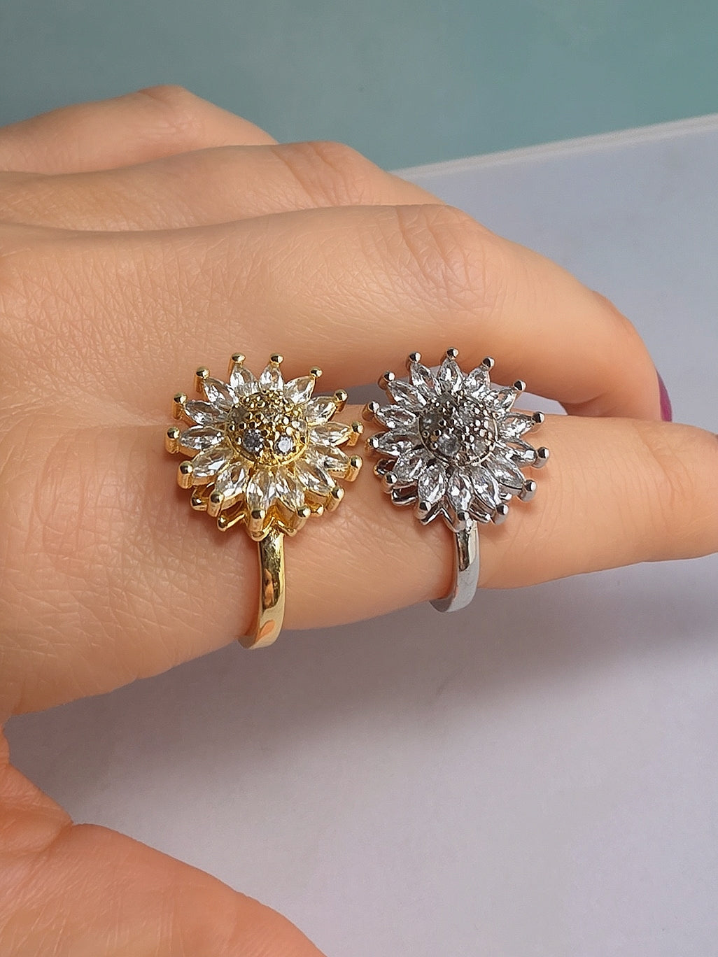 Floral fidget ring with a polished gold-plated finish and rotating design.