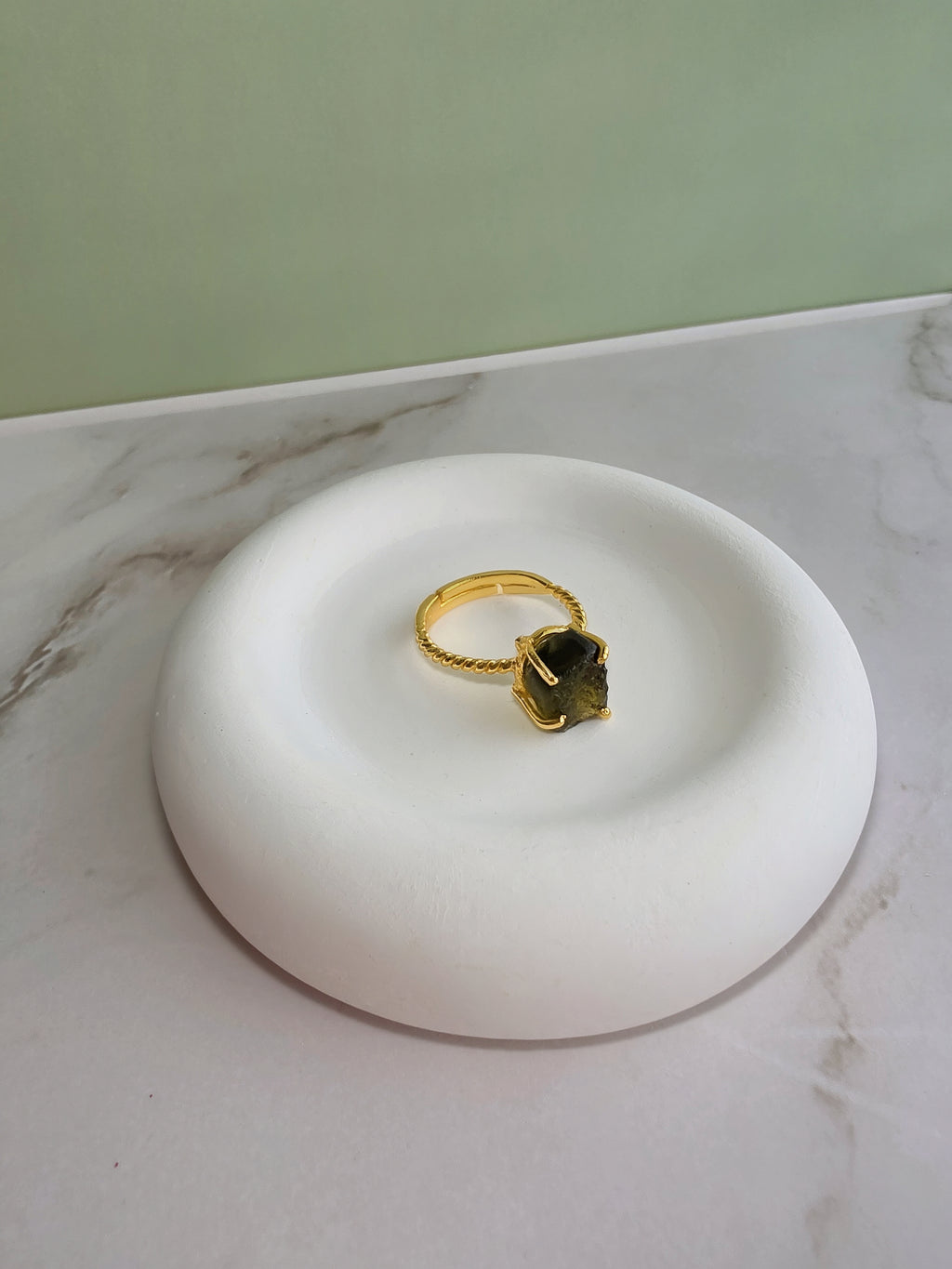 Unique raw moldavite gemstone ring with a modern adjustable gold-plated setting.