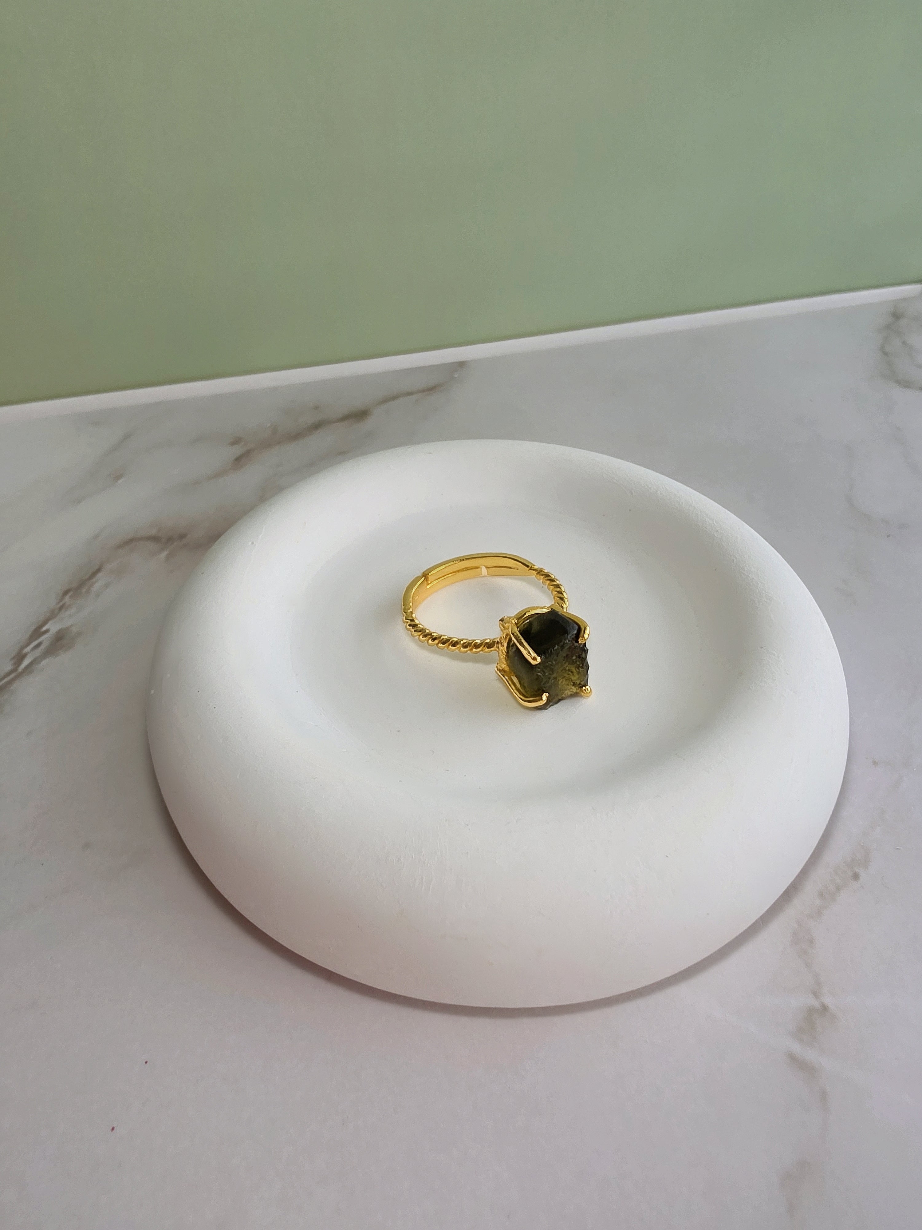 Unique raw moldavite gemstone ring with a modern adjustable gold-plated setting.