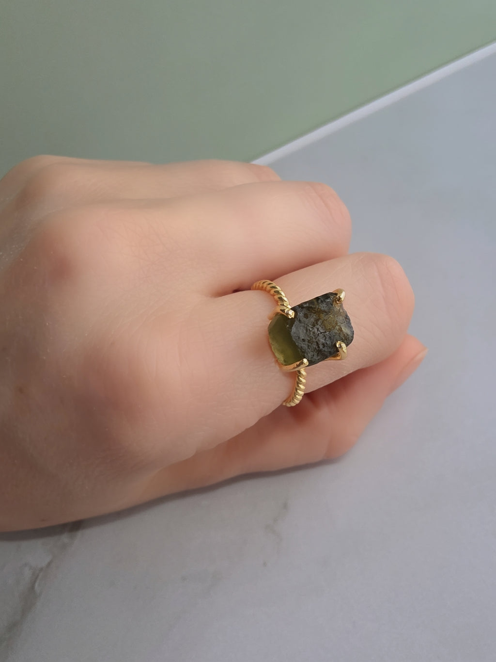 Elegant raw moldavite crystal ring featuring a natural green gemstone and adjustable gold-plated band.