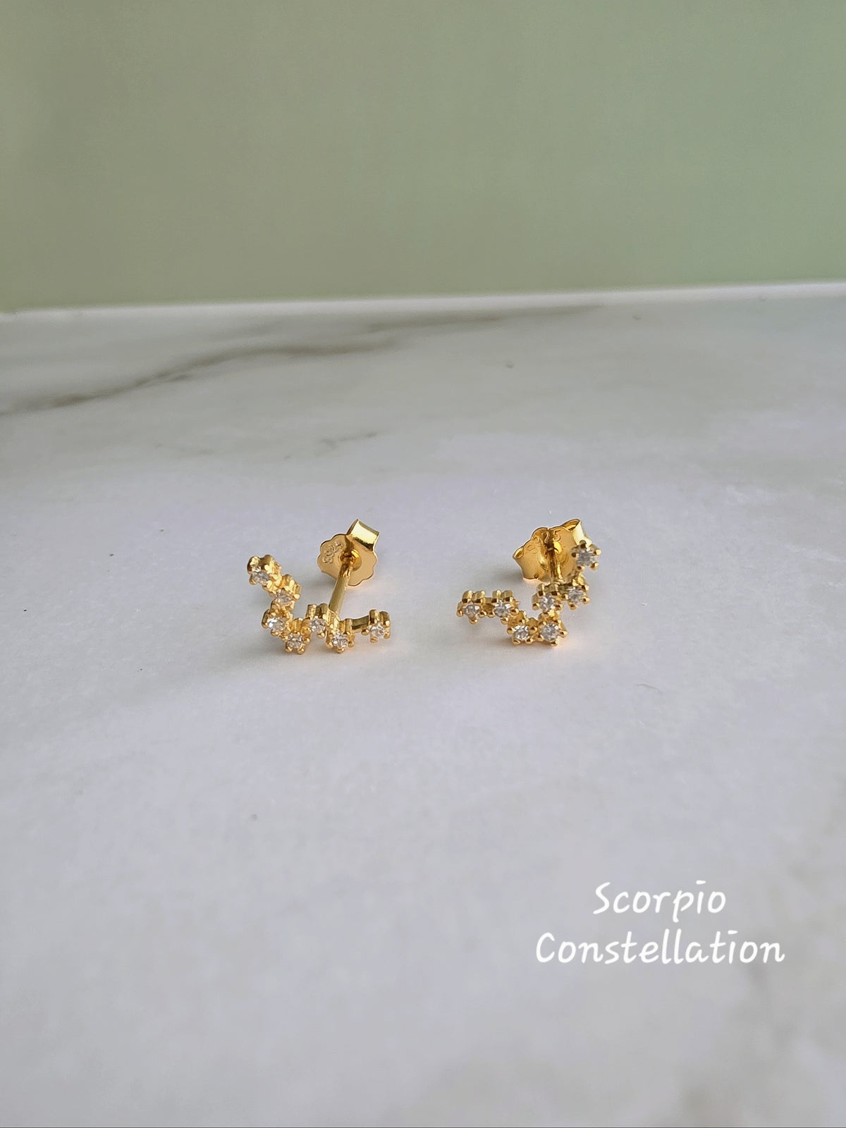 Celestial zodiac earrings with sparkling constellation details.