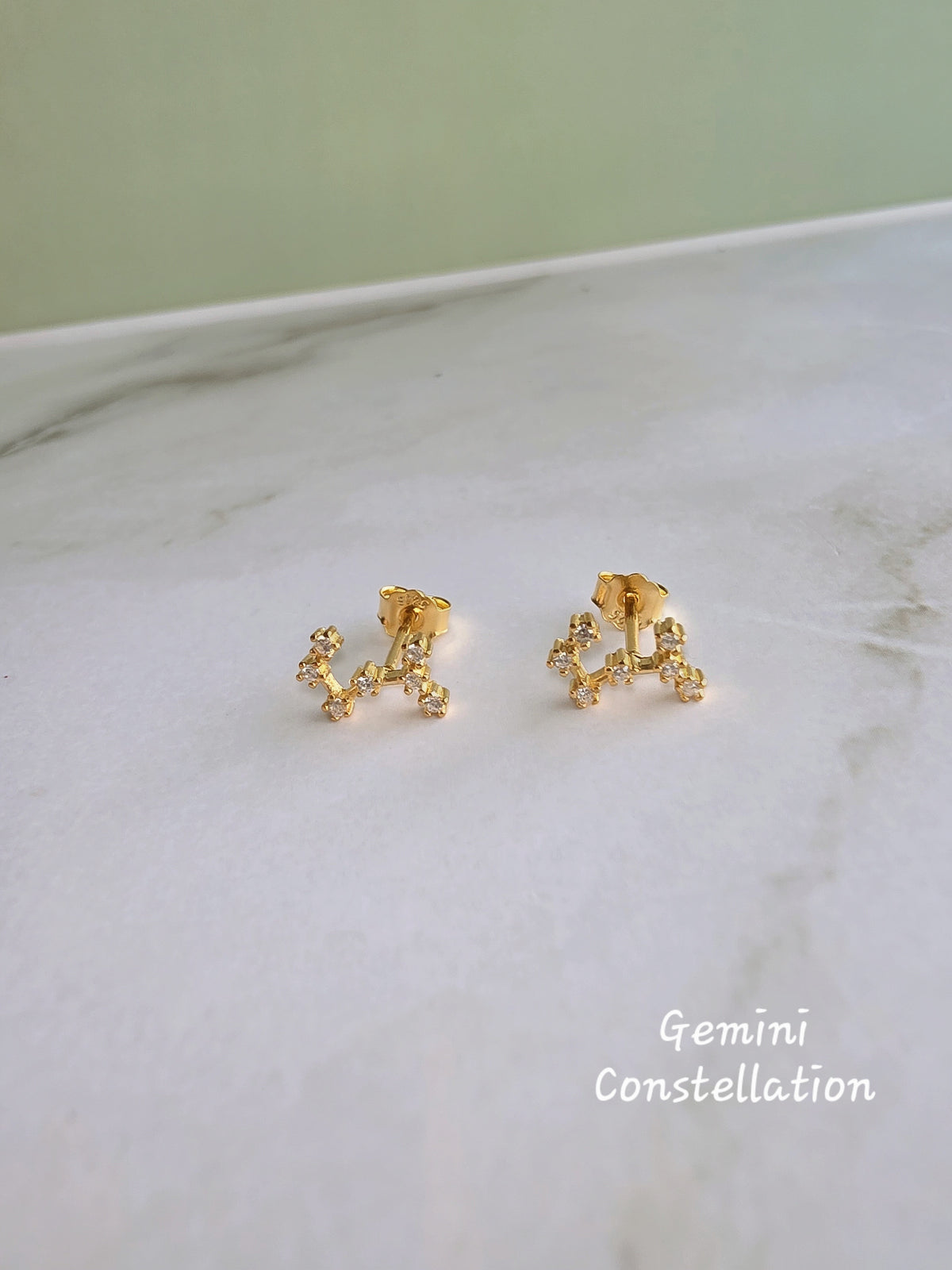 Gold-plated celestial earrings inspired by zodiac constellations.