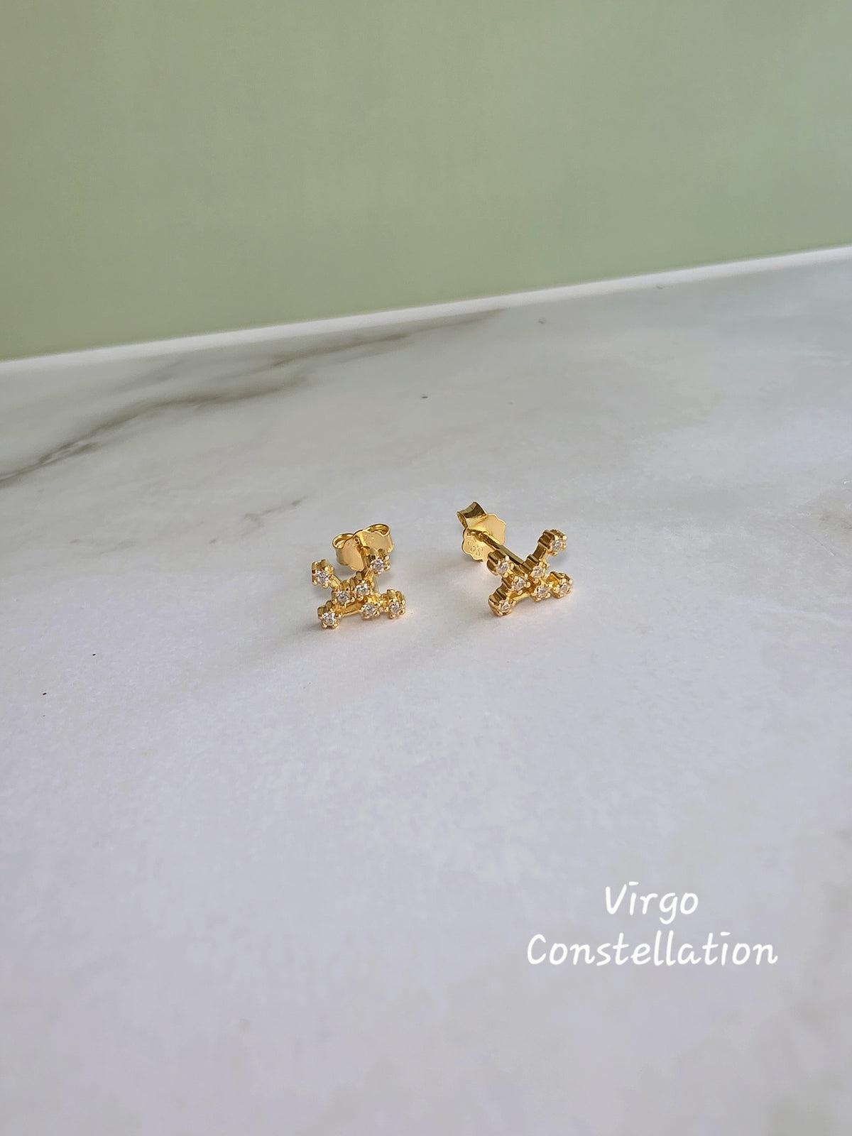 Dainty zodiac earrings crafted from sterling silver and 14K gold plating.