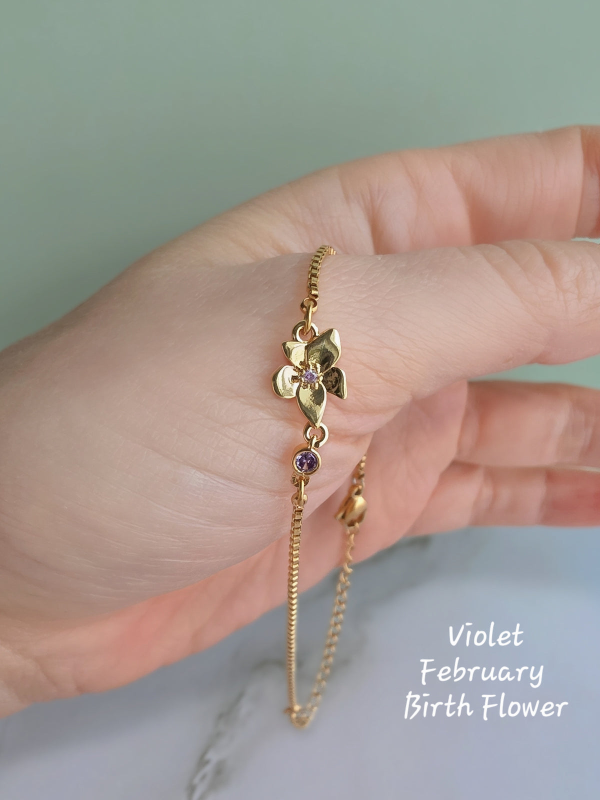Adjustable birth flower bracelet with an engraved botanical charm.