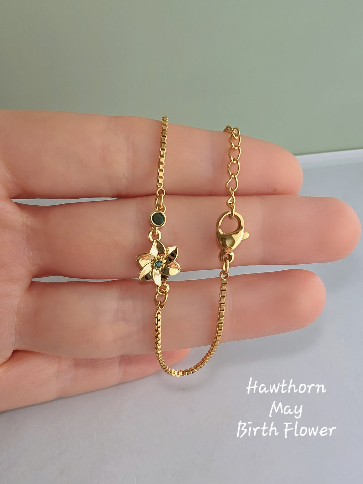 Gold birth flower bracelet with a sparkling birthstone charm.