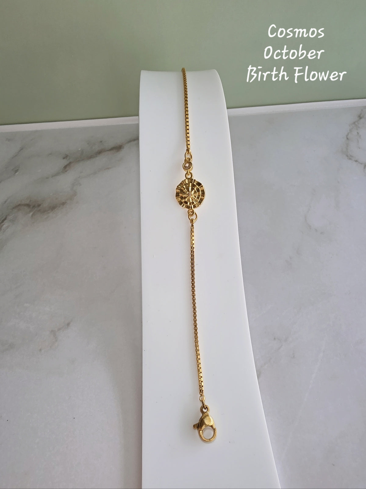 Adjustable gold bracelet with a birth flower and birthstone.
