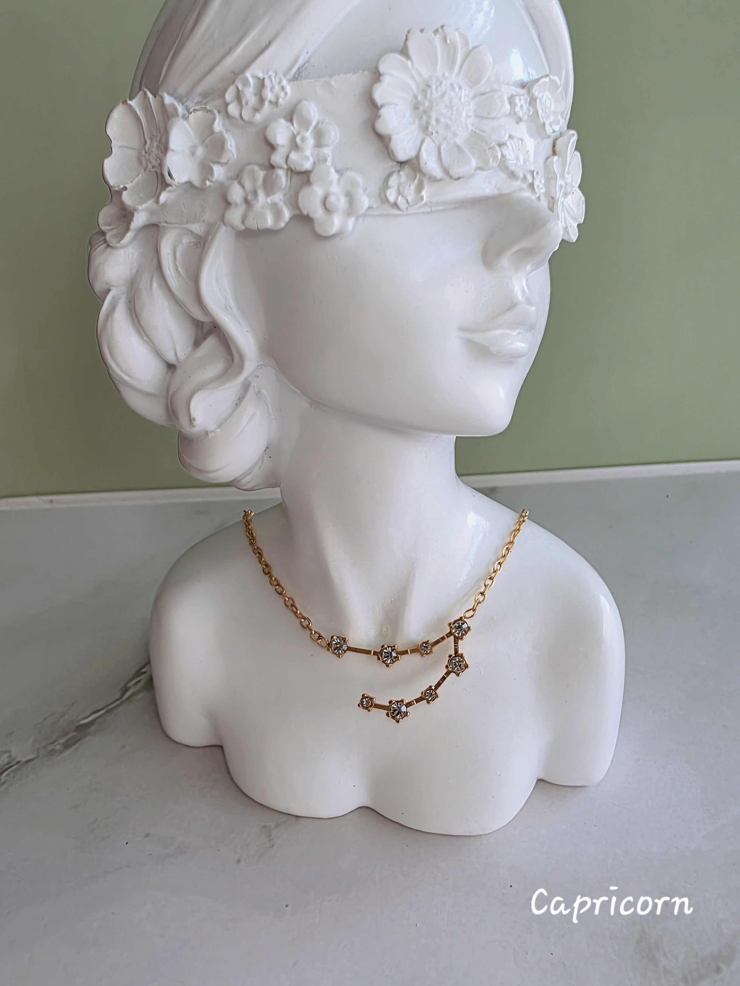Gold zodiac necklace with sparkling constellation details.