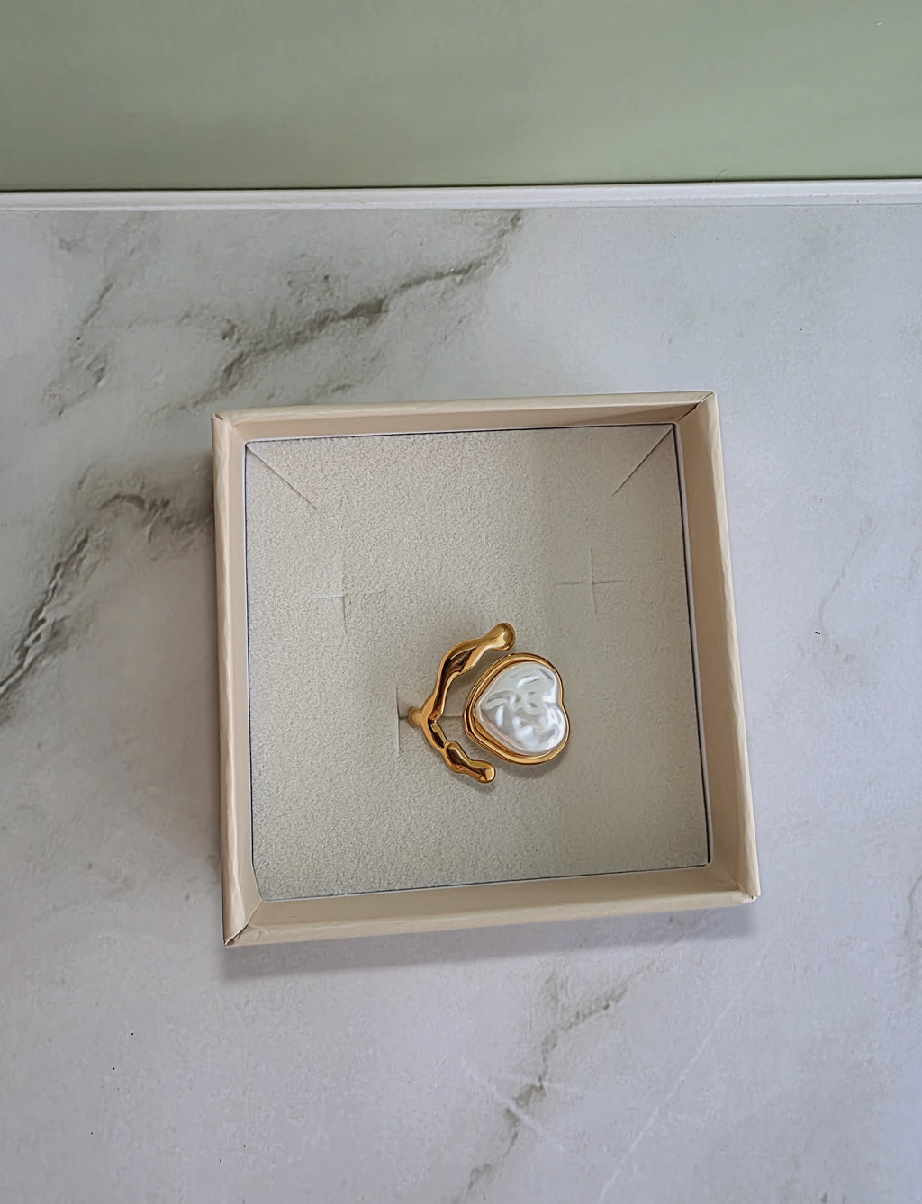 Adjustable chunky gold ring with a sculptural heart and pearl.