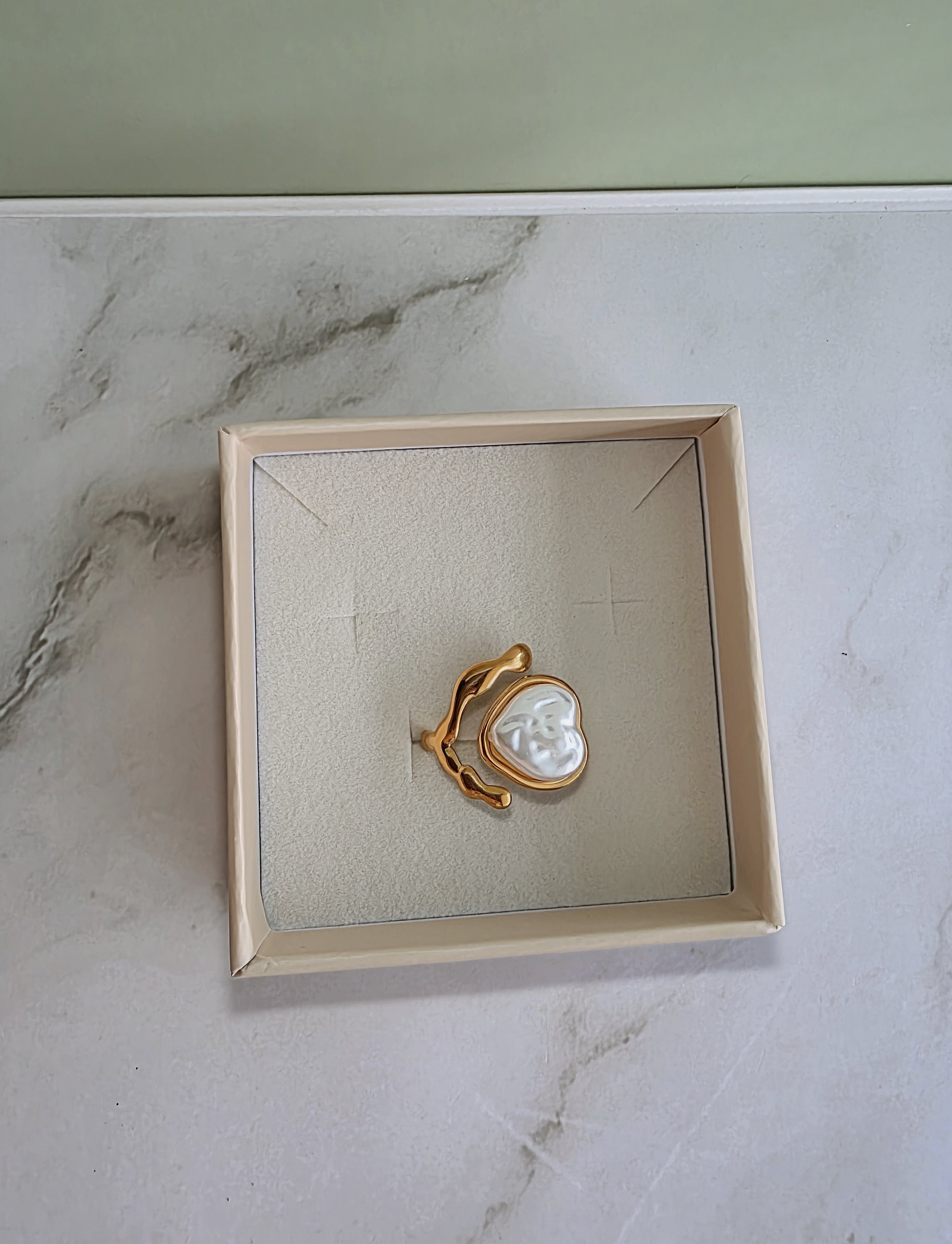 Adjustable chunky gold ring with a sculptural heart and pearl.