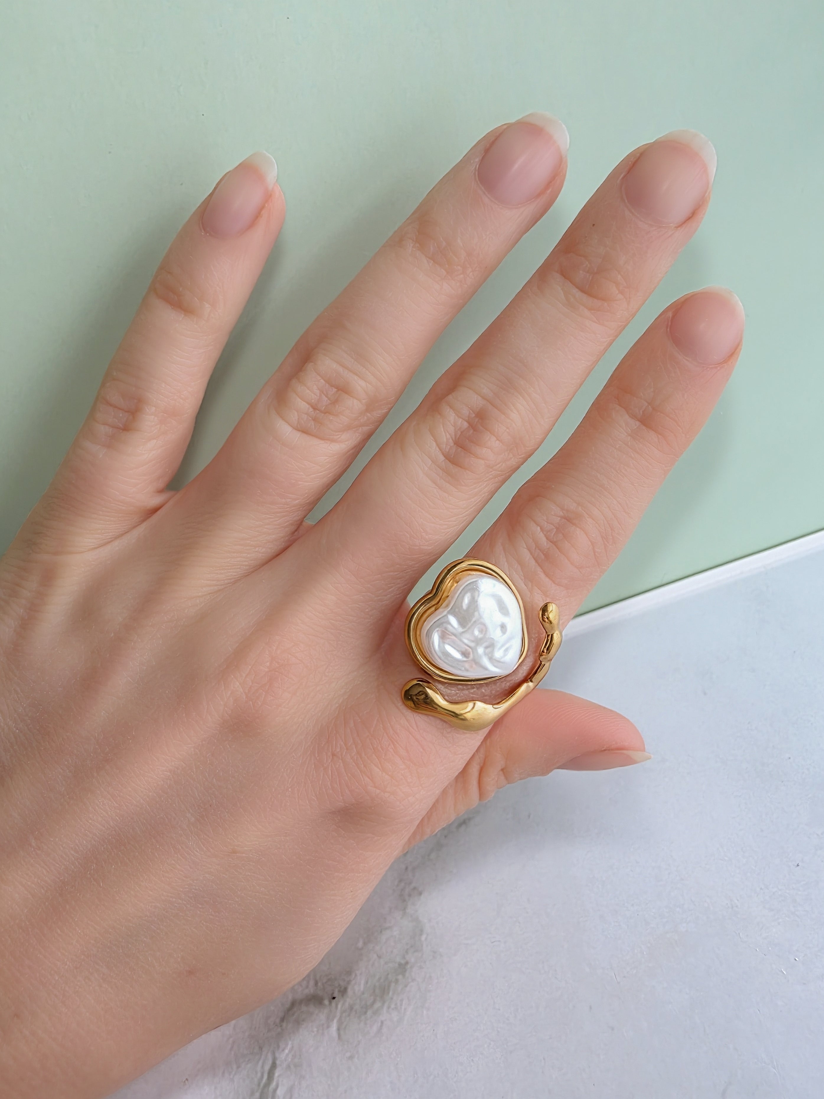 Molten-inspired gold ring with an elegant heart pearl.