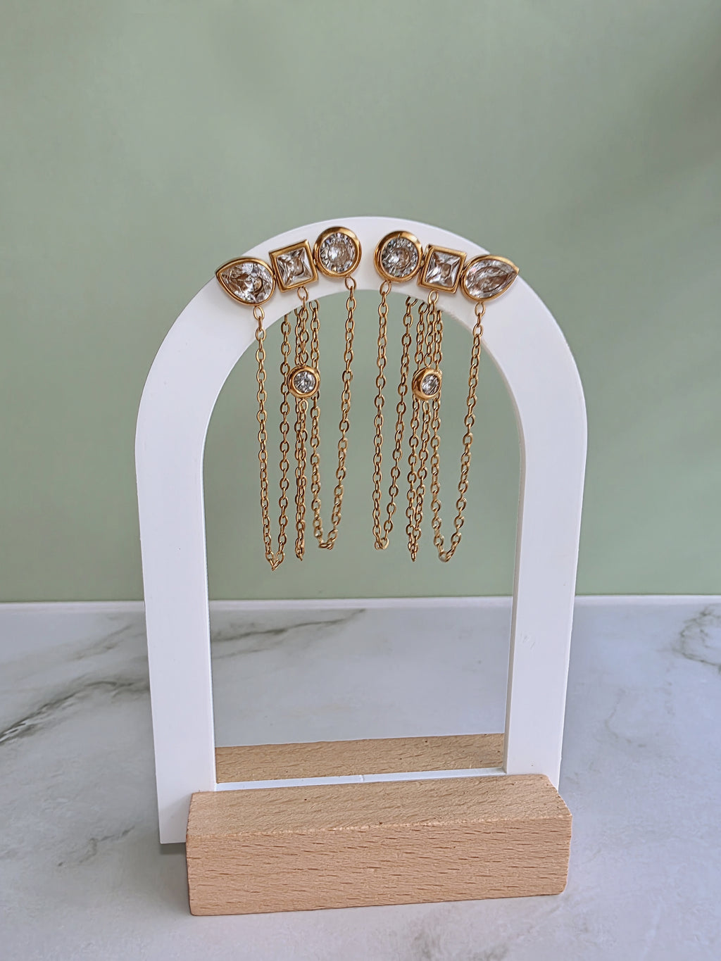 Elegant geometric chain earrings featuring round, square, and marquise cubic zirconia stones.