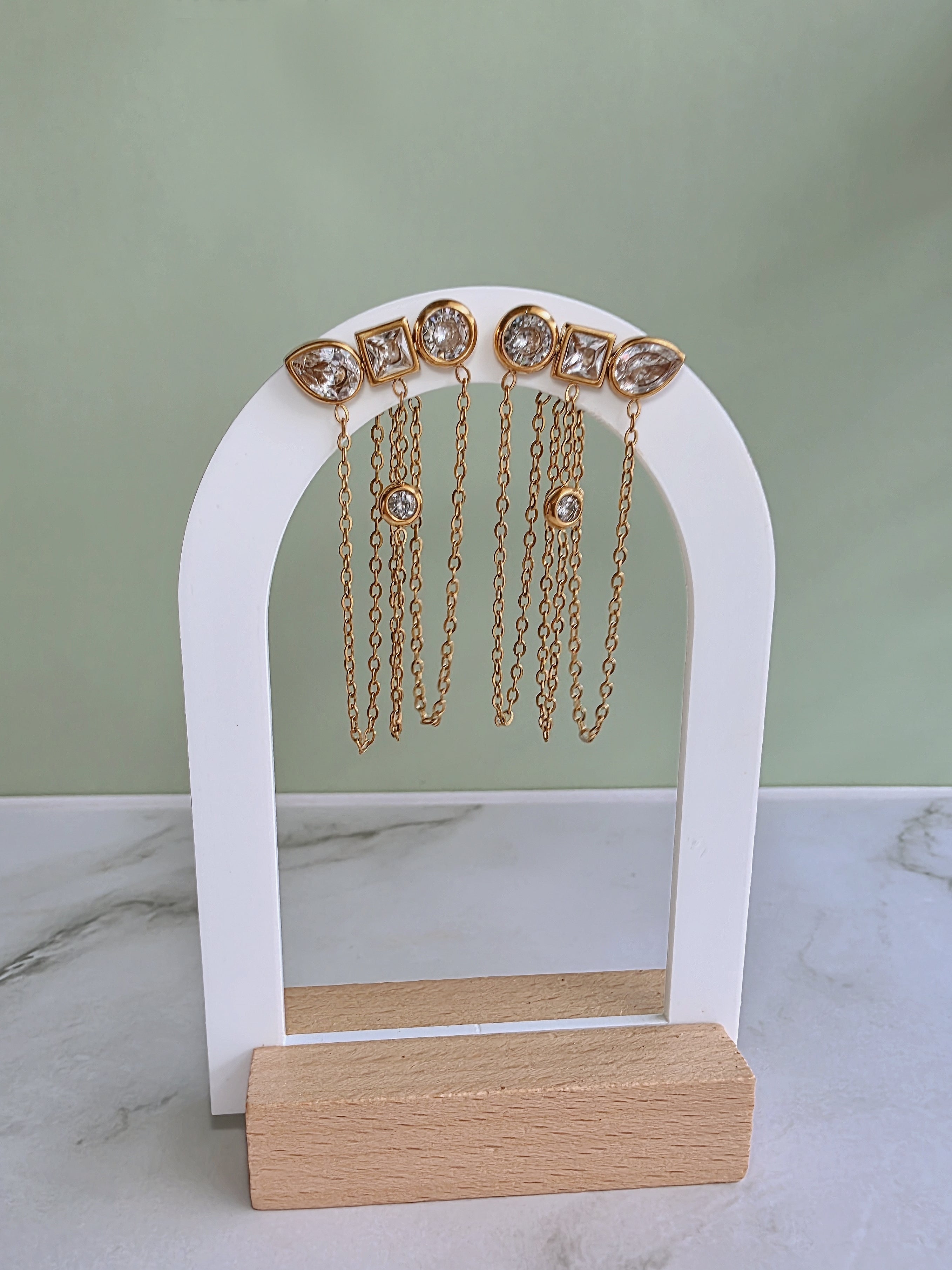 Elegant geometric chain earrings featuring round, square, and marquise cubic zirconia stones.