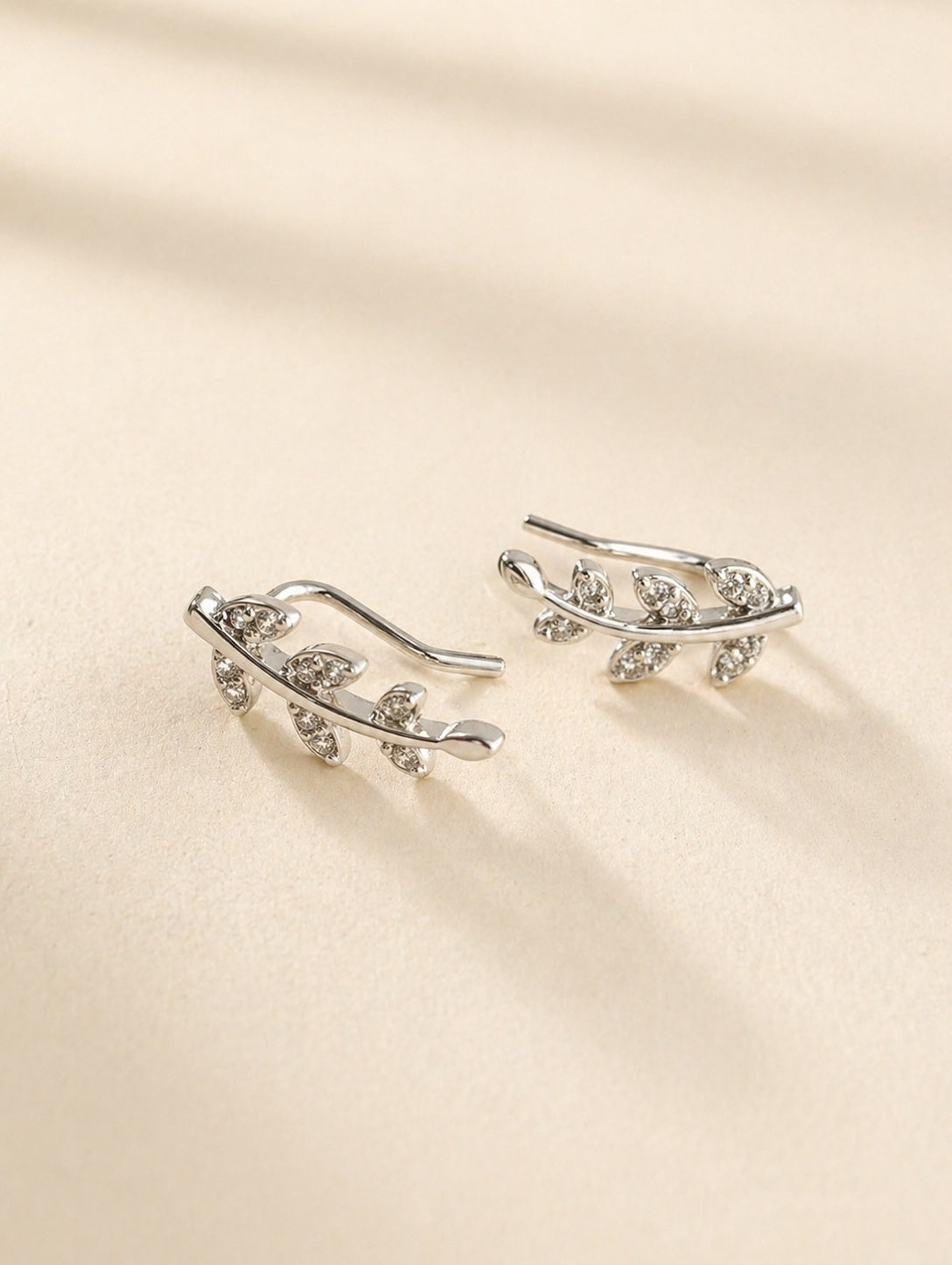 Gold floral vine ear crawler earrings with cubic zirconia accents.